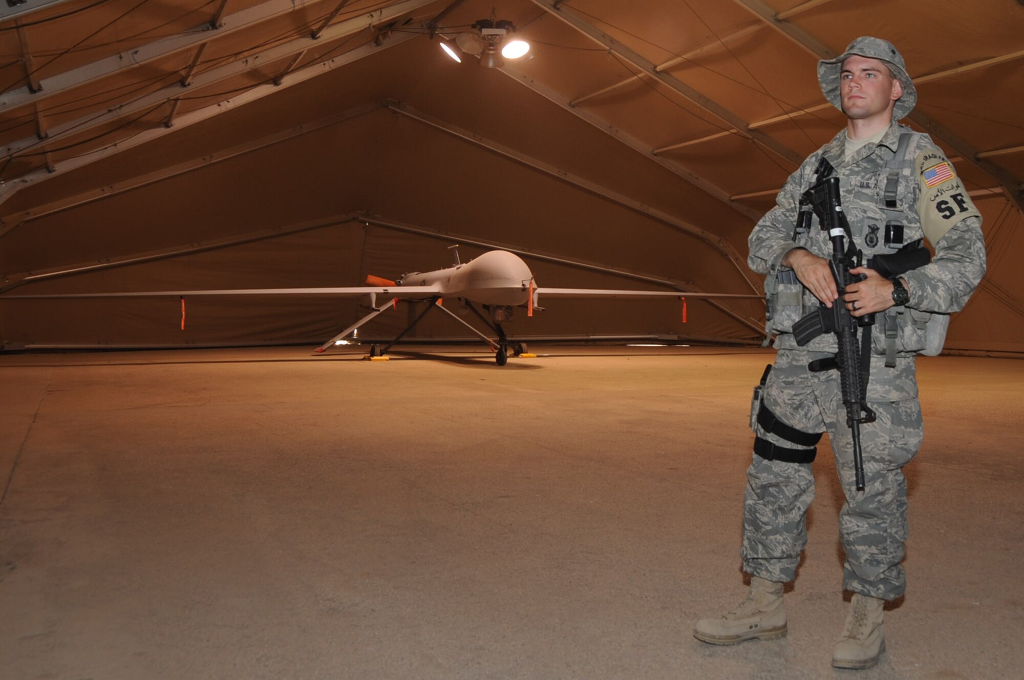 ALI BASE, Iraq -- Airman 1st Class Christopher Wilson, 407th Expeditionary Security Forces Squadron, guards an MQ-1 Predator here June 17. He was selected as the 407th Air Expeditionary Group Warrior of the Week for the week of June 16. He is deployed from McGuire AFB, N.J. (U.S. Air Force photo/Tech. Sgt. Sabrina Johnson) 