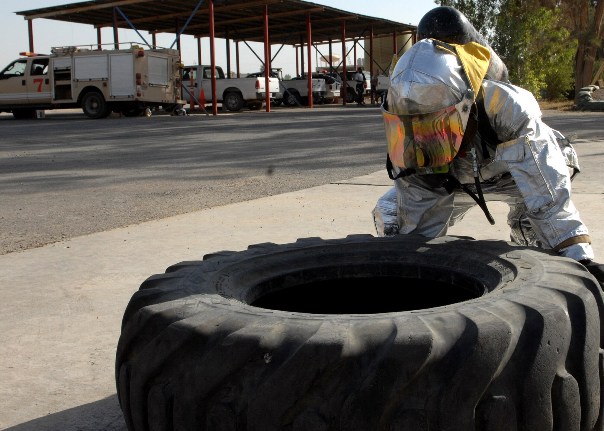 KIRKUK REGIONAL AIR BASE, Iraq – An Airman from the 506th Expeditionary Civil Engineer Squadron Fire and Emergency Services Flight flips a tire during a training event June 16 here. The event tested the flight's ability to respond to an emergency situation in the deployed setting. (U.S. Air Force photo by Senior Airman SerMae Lampkin) 