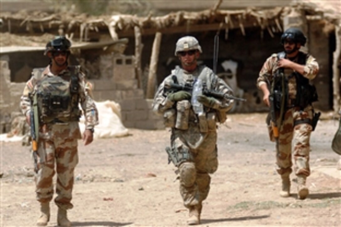 U.S. Army Capt. Eric Morton, center, commander of the 101st Airborne Division's Company B, 1st Battalion, 35th Armor Regiment, walks with Iraqi Maj. Ahmed Hassan and Iraqi 1st Lt. Yasev Mutasam through Shakriyah, Iraq, area during Operation New Town, June 10, 2008. New Town is a census operation in which photos of all military-age males are taken and weapons in households are counted. 