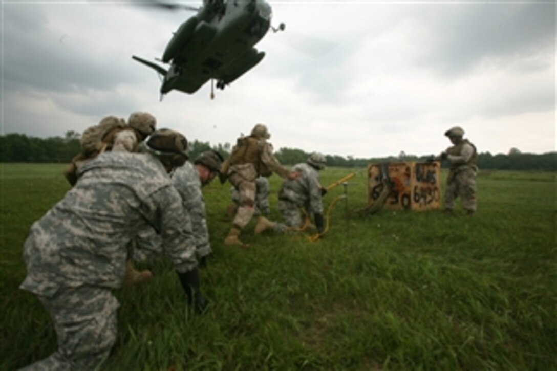 U.S. Marines assigned to Combat Logistics Battalion 26, 26th Marine Expeditionary Unit and soldiers from the 638th Aviation Support Battalion, Indiana Army National Guard prepare to attach a cargo box to a CH-53E Super Stallion helicopter at Camp Atterbury, Ind., on June 13, 2008.  The service members are conducting realistic urban training exercises to prepare for deployments later in the fall.  