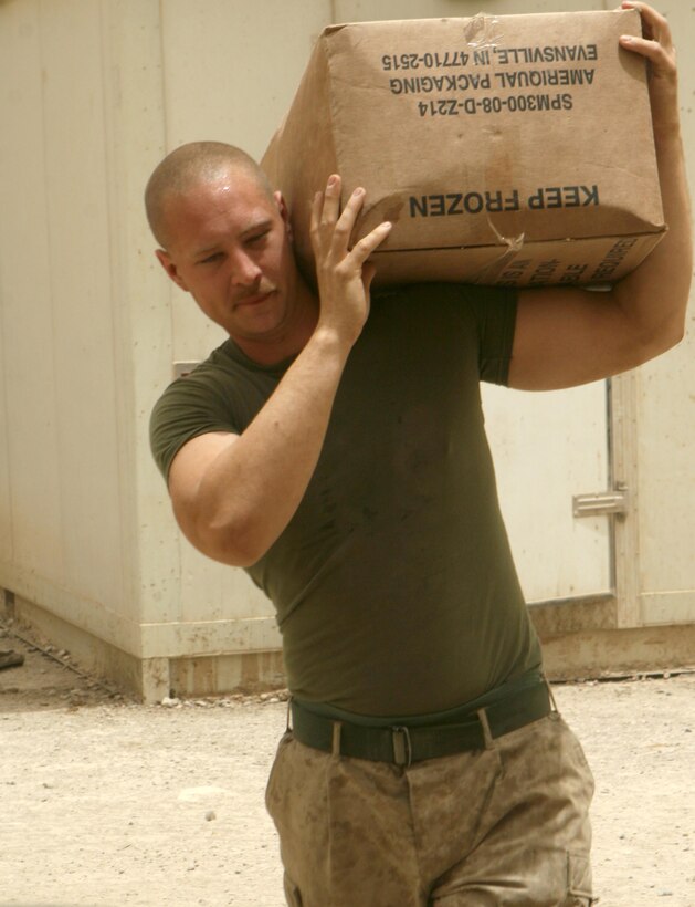 Lance Cpl. Alfred Lindquist, a food service specialist with 1st Battalion, 9th Marines, who is currently cooking for the Marines at a joint security station inside the city, carries a box of beef to the area’s cooking space in preparation for dinner June 16. (Official U.S. Marine Corps photo by Lance Cpl. Casey Jones)