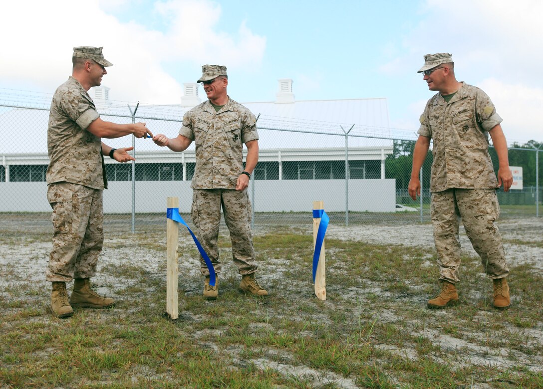 From left to right, 1st Sgt. Jason Gillespie, first sergeant of Military Police Support Company, II Marine Expeditionary Force Headquarters Group; Maj. Matt Mestemaker, commanding officer MP Support Co.; and Col. Scott Aiken, commanding officer of II MHG, cut the ribbon symbolizing the opening of MP Support Company’s new consolidated work environment, May 5, 2010. The ribbon-cutting was a symbol of the new working environment being open for business.