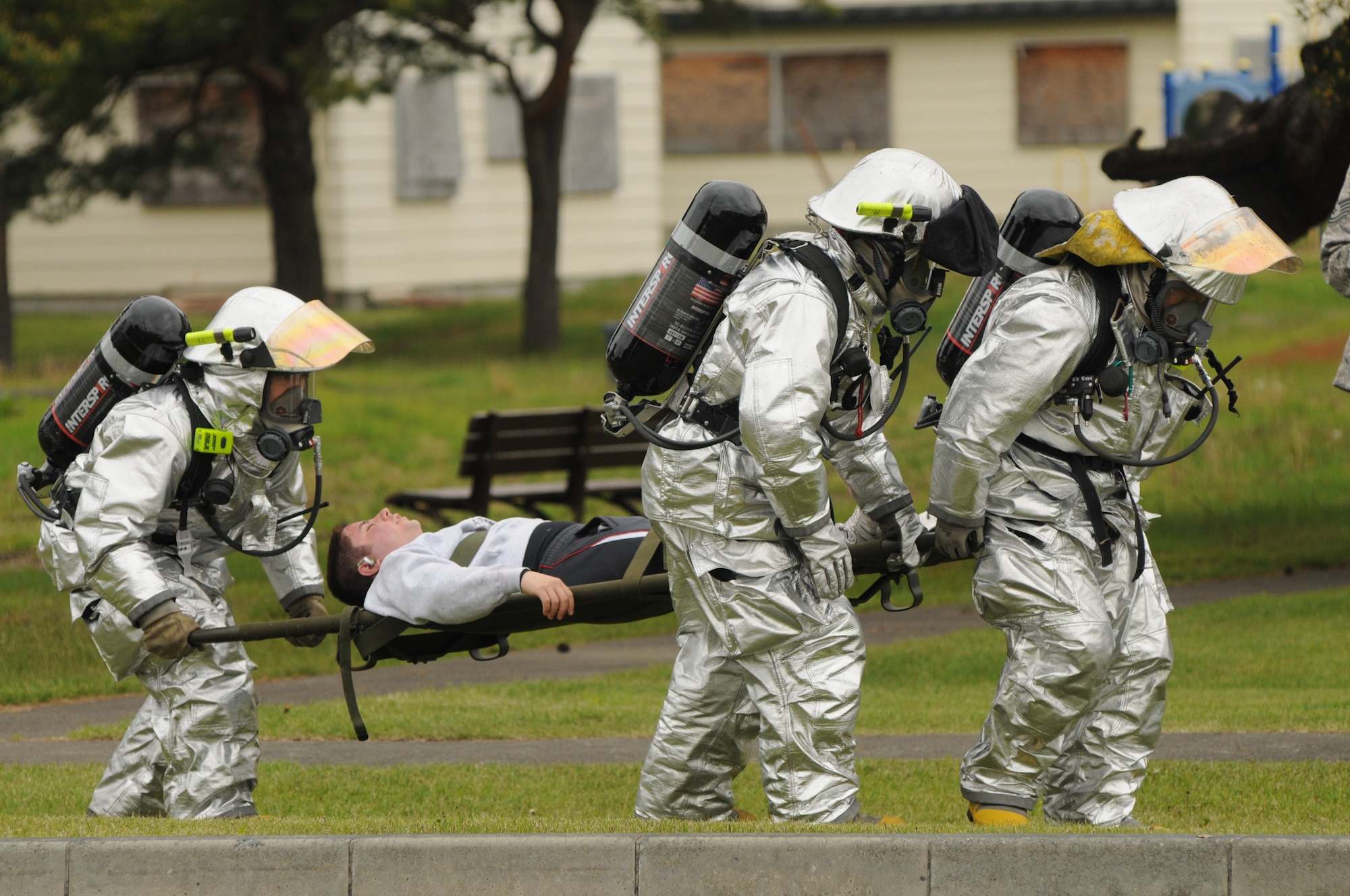 MISAWA AIR BASE, Japan -- Misawa firefighters work together to bring a simulated victim to safety during the two simulated explosions caused by terrorists May 28. Misawa’s Emergency Management program integrates the effects of major accidents, natural disasters, conventional attacks and terrorist use of chemical, biological, radiological and nuclear materials in an exercise. (U.S. Air Force photo by Staff Sgt. Samuel Morse)