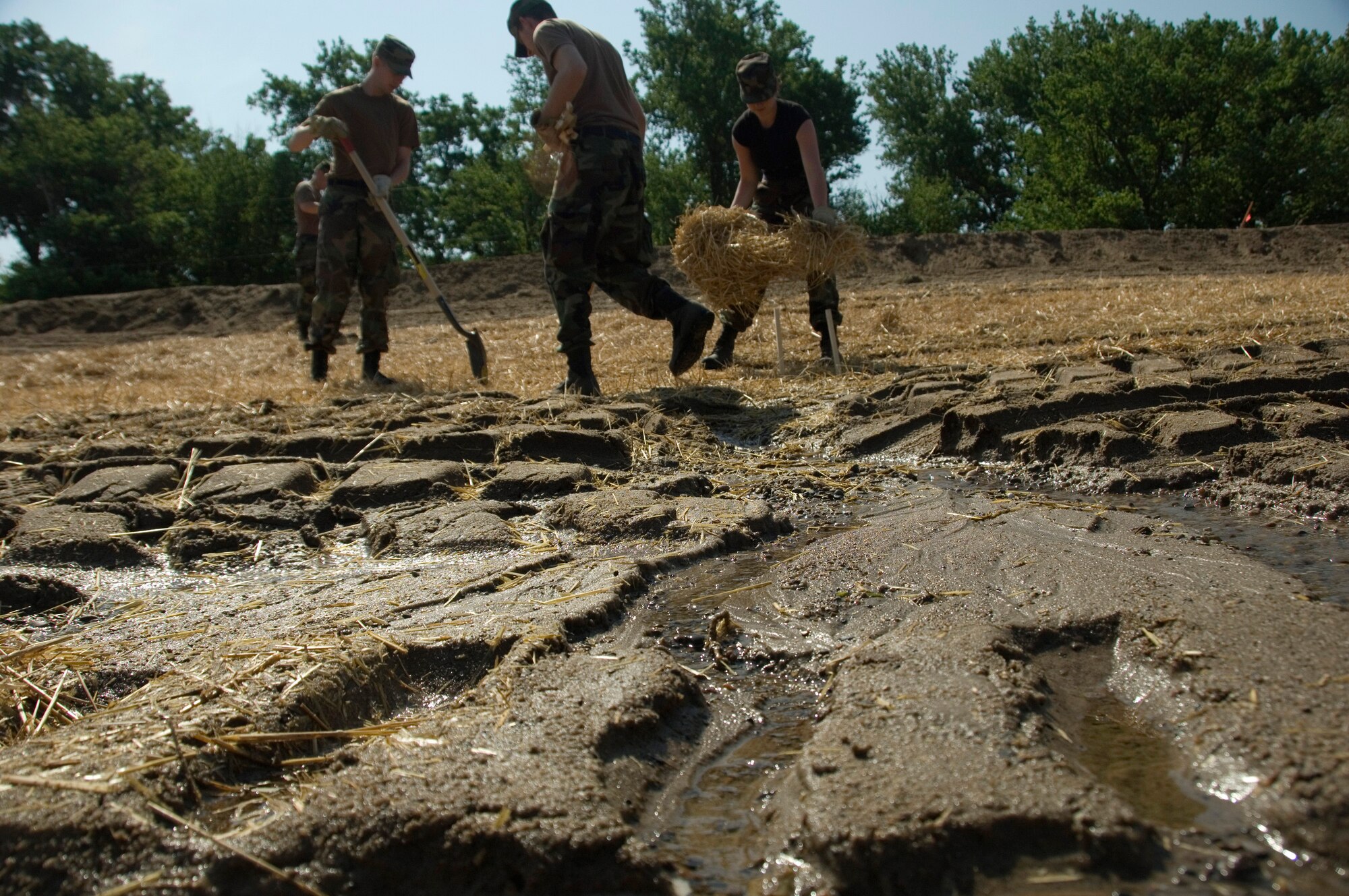 Members of the Iowa Air National Guard use a mixture of sand and hay to prevent levee erosion along the Mississippi River June 18 near Burlington, Iowa. The members of the 185th Air Refueling Wing at Sioux City, Iowa, are helping to protect approximately 14,000 acres of farmland from erosion. (U.S. Air Force photo/Master Sgt. Jack Braden) 

