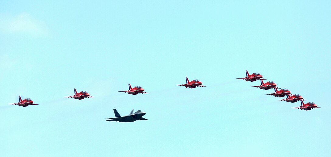 LANGLEY AIR FORCE BASE, Va. – Maj. Paul "Max" Moga, F-22A Raptor Demonstration Team pilot, flies in formation with the British Royal Air Force Aerobatic Team, The Red Arrows, during an afternoon practice flight here June 18. The Red Arrows will perform at AirPower over Hampton Roads, Langley’s air show, which is scheduled for June 20 to 22. (U.S. Air Force photo/Airman 1st Class Aaron Johnson)
