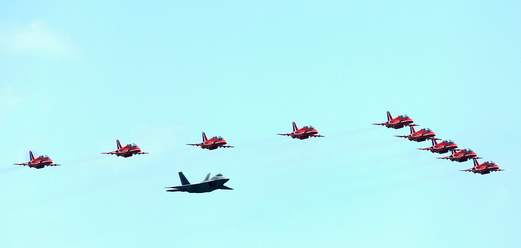 LANGLEY AIR FORCE BASE, Va. – Maj. Paul "Max" Moga, F-22A Raptor Demonstration Team pilot, flies in formation with the British Royal Air Force Aerobatic Team, The Red Arrows, during an afternoon practice flight here June 18. The Red Arrows will perform at AirPower over Hampton Roads, Langley’s air show, which is scheduled for June 20 to 22. (U.S. Air Force photo/Airman 1st Class Aaron Johnson)
