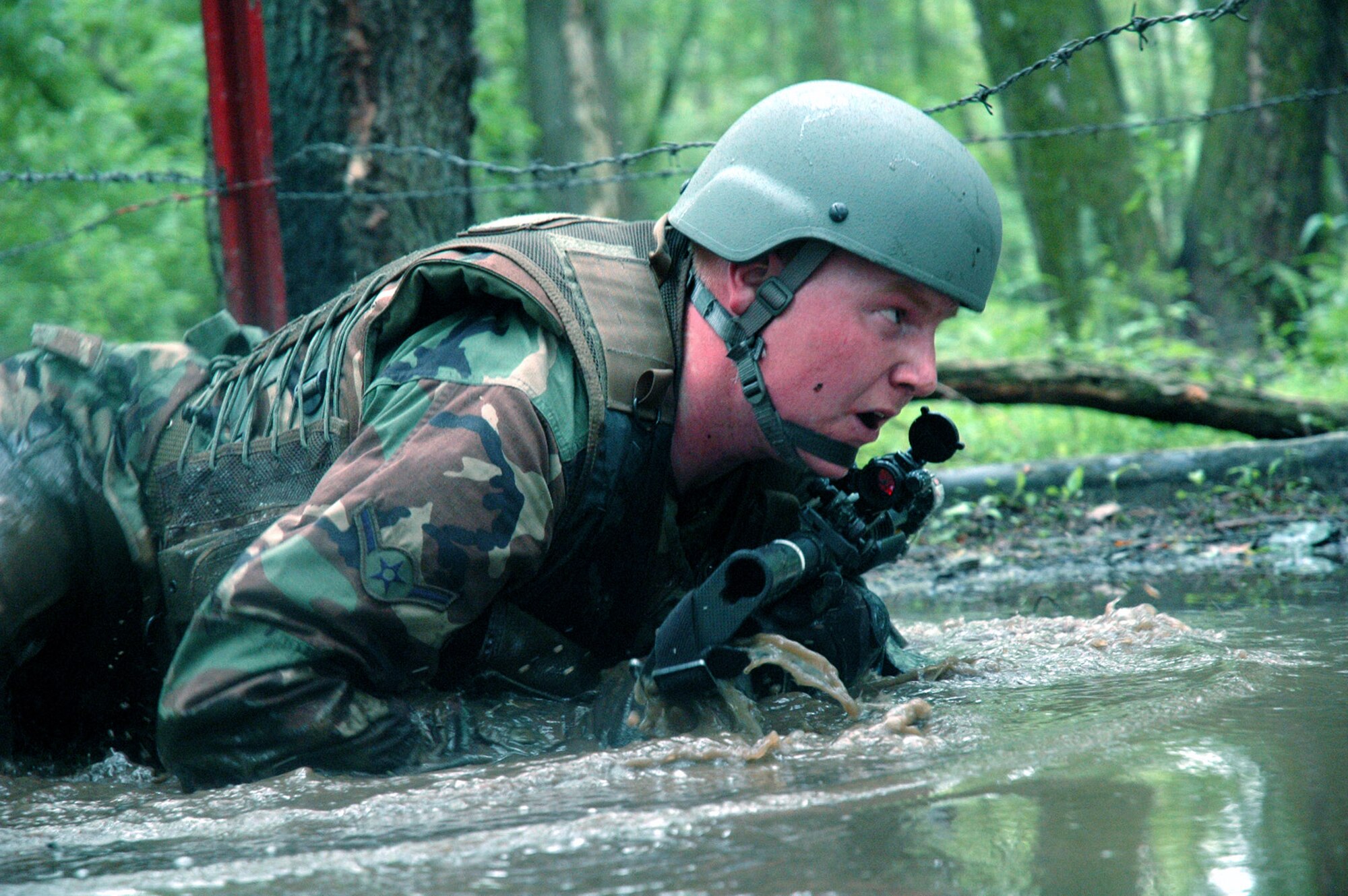 A student in the Air Force Phoenix Warrior Training Course crawls under barbed wire and through water during combat first aid class training June 5 at Fort Dix, N.J. The course is taught by members of Air Force Expeditionary Center's Expeditionary Operations School and 421st Combat Training Squadron and prepares Airmen for upcoming deployments. Annually, the course trains more than 23,000 students in expeditionary- and mobility air force-based courses both with in-residence and distance learning. (U.S. Air Force photo/Tech. Sgt. Scott T. Sturkol) Annually, the USAF EC trains more than 23,000 students in expeditionary- and mobility air force-based courses both with in-residence and distance learning.  (U.S. Air Force Photo/Tech. Sgt. Scott T. Sturkol)