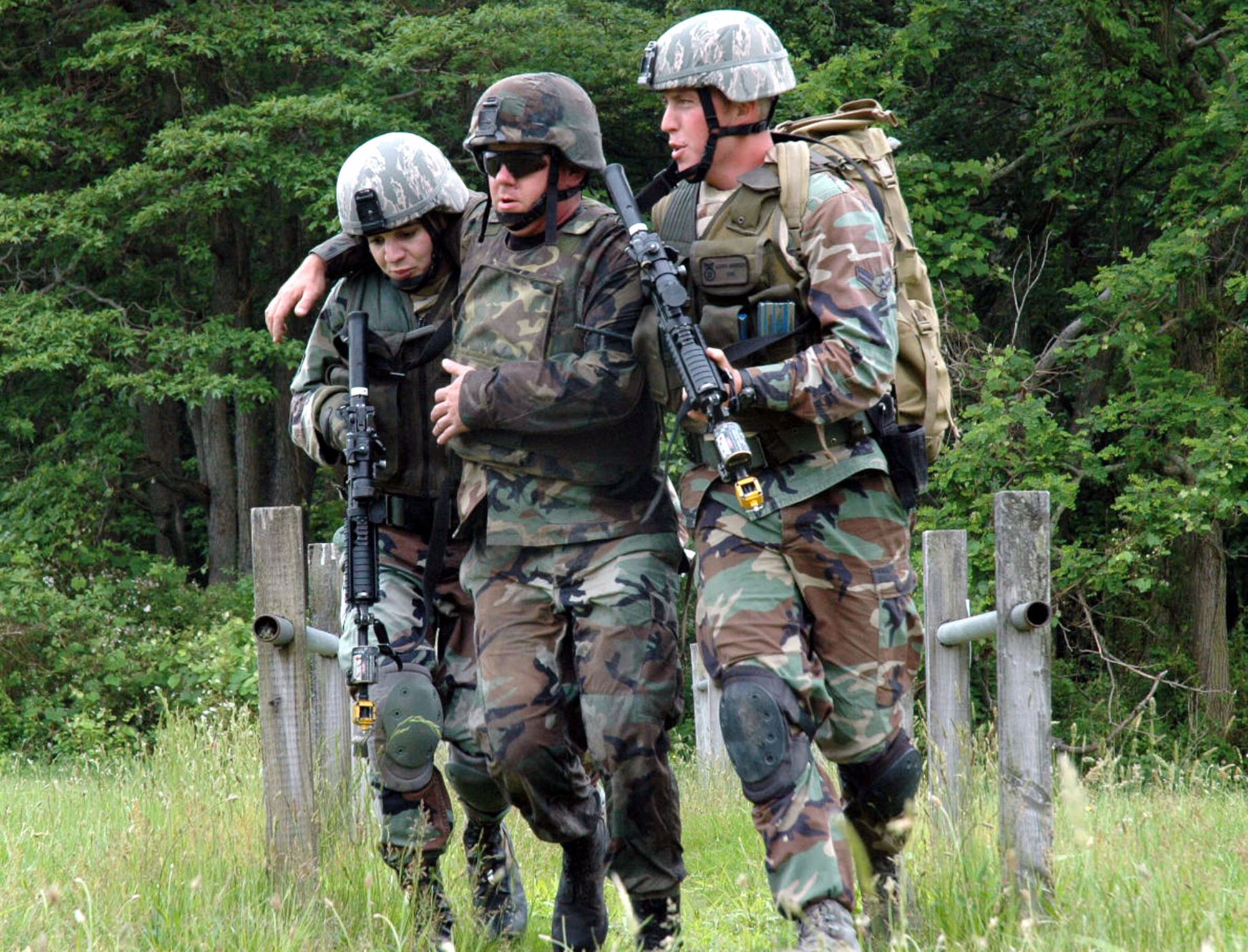 1st Lt. Yuliya Buquoi and Airman 1st Class Charles Bryant, assist Staff Sgt. Michael Richmond, playing the role of a victim during combat first aid training June 5 at Fort Dix, N.J. Lieutenant Buquoi is assigned to the 88th Security Forces Squadron, Wright-Patterson Air Force Base, Ohio and Airman Bryant is from the 30th SFS, Vandenburg Air Force Base, Calif. (U.S. Air Force Photo/Staff Sgt. Paul R. Evans) 
