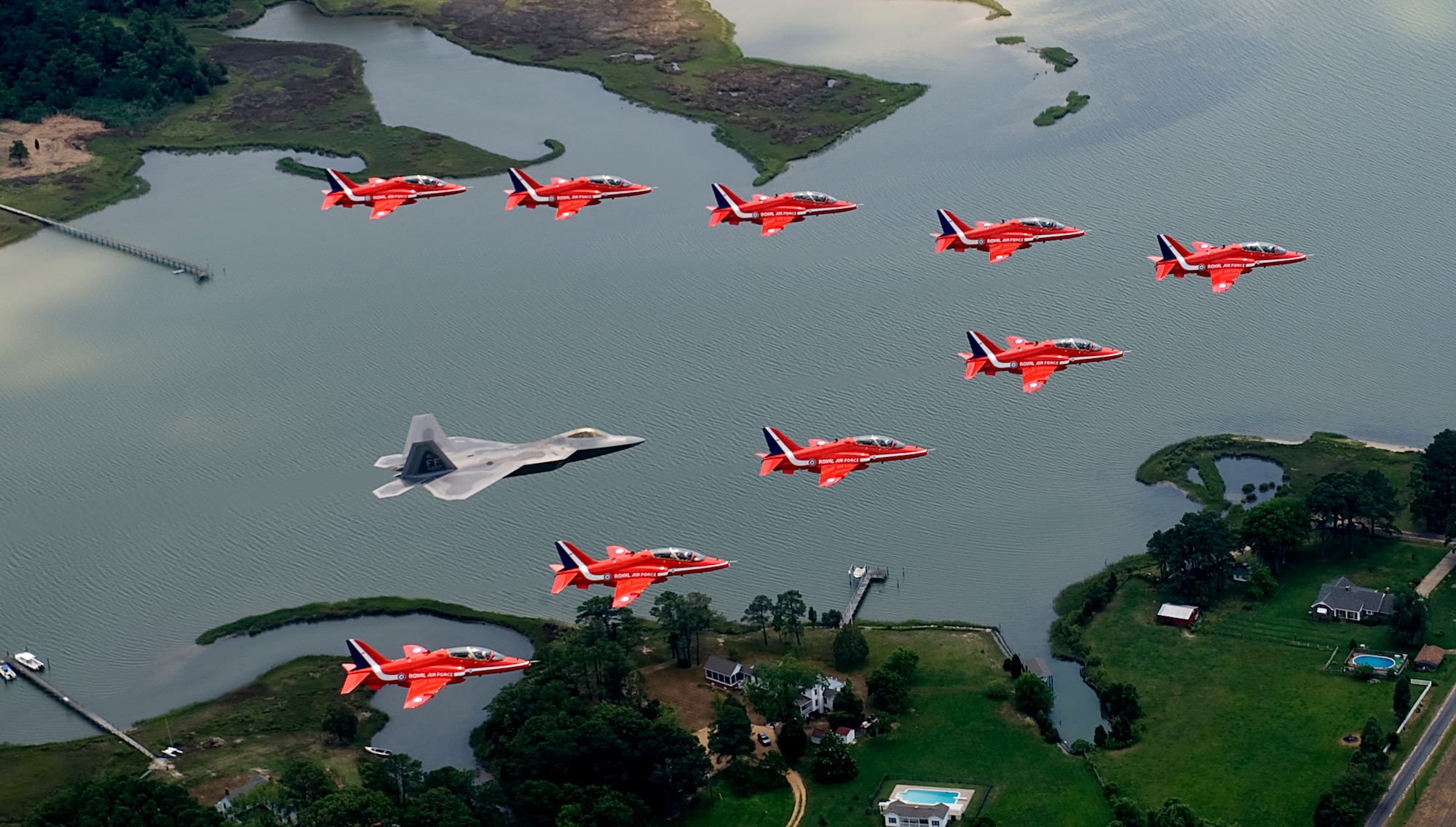 LANGLEY AIR FORCE BASE, Va. – Maj. Paul "Max" Moga, F-22A Raptor Demonstration Team pilot, flies in formation with British Royal Air Force Aerobatic Team, The Red Arrows, during an afternoon practice flight here June 18. Both demonstration teams will perform at AirPower over Hampton Roads, Langley’s air show, which is scheduled for June 20 to 22. (U.S. Air Force photo/Staff Sgt. Samuel Rogers)