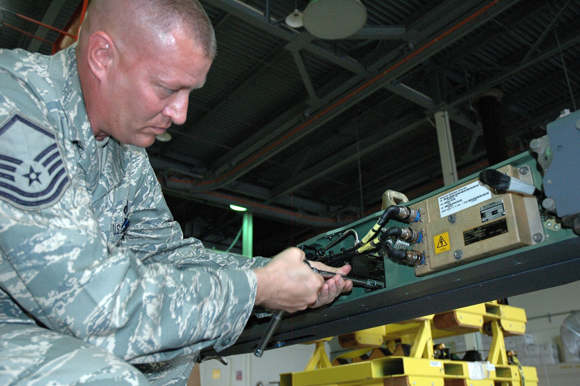 EGLIN AIR FORCE BASE, Fla. -- Master Sgt. Brian Mosier, 681st Armament Systems Squadron Small Diameter Bomb Logistics Team, tightens peices inside the pneumatic carriage system that holds and discharges the SDB to its carrier aircraft. Sergeant Mosier is in the final stages addressing an issue detected with the carriage system. (U.S. Air Force photo/Staff Sgt. Stacia Zachary)