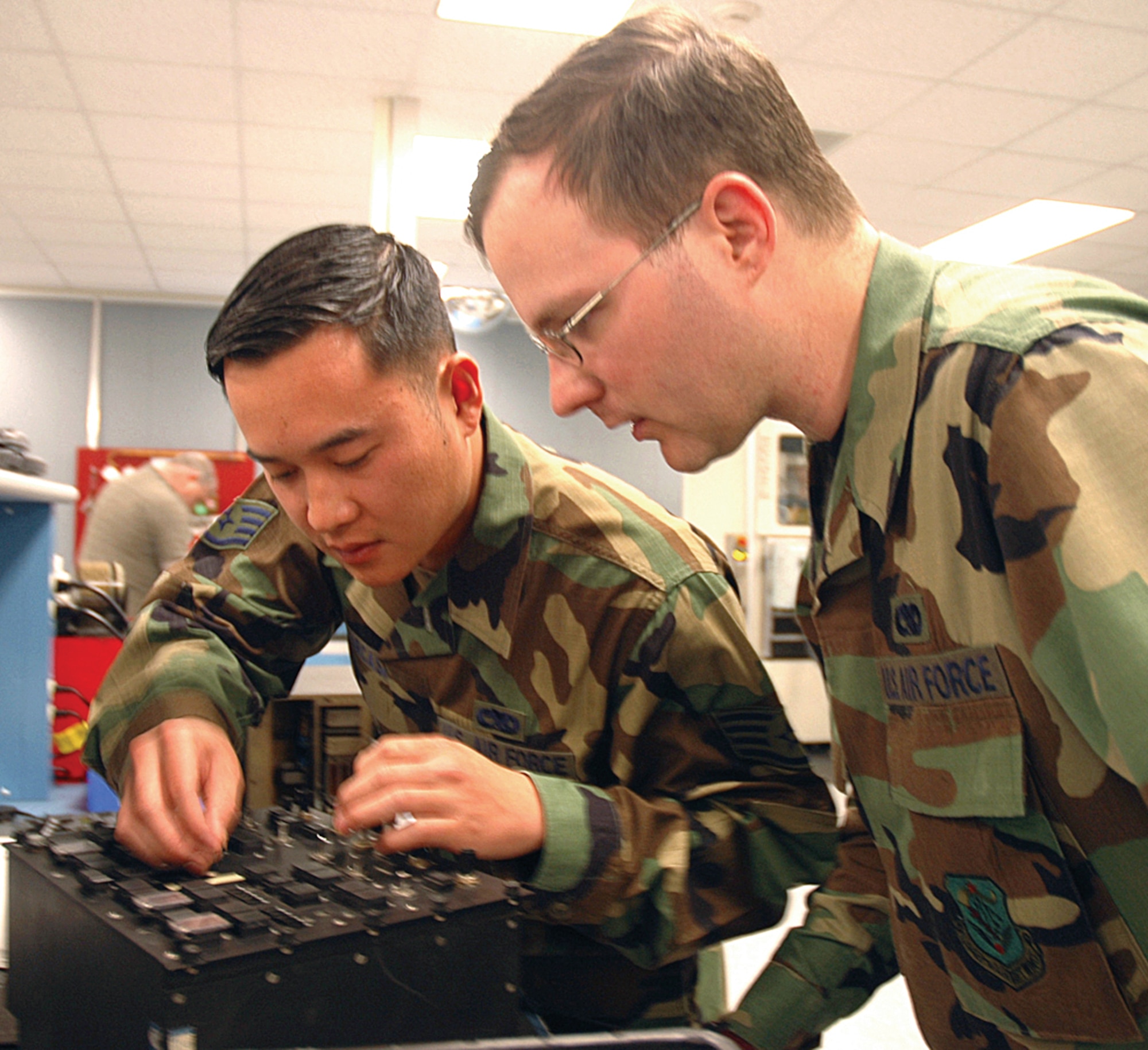 Staff Sgt. Christopher Parcasio, left, demonstrates how to repair a Fuel System Engine Start control panel to his troop, Senior Airman Buell Richardson, an avionics technician with the 446th Maintenance Squadron, McChord Air Force Base, Wash. (U.S. Air Force photo/Tech. Sgt. Jake Chappelle)