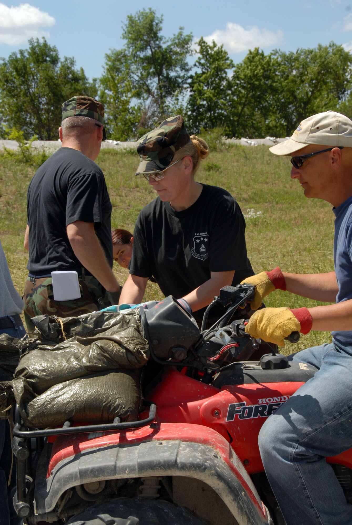 MSgt. Connie Miller  a member of the 185 Air Refueling Wing (ARW) based in Sioux City, Iowa, loads sandbags on a civilian ATV to help reinforce a levee North of Burlington, Iowa.  The 15-mile long levee, built in the early 1930's, needed to be raised due to record flood levels.
Official Air Force Photo by: MSgt. Bill Wiseman
Photo Released by: Capt. Kevin Heinenman 185 ARW/PAO
