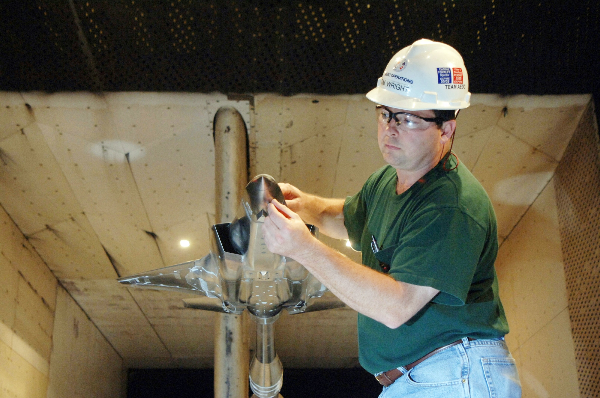 Tim Wright examines the short takeoff/vertical landing F-35 Lightning II Joint Strike Fighter model in the 16 -foot transonic wind tunnel at the Arnold Engineering Development Center at Arnold Air Force base, Tenn . The information from this testing will go into a large database to refine and validate the aircraft designs for flight testing and ultimately, production. Mr. Wright is an aerospace testing alliance craftsman at the center. (U.S. Air Force photo) 