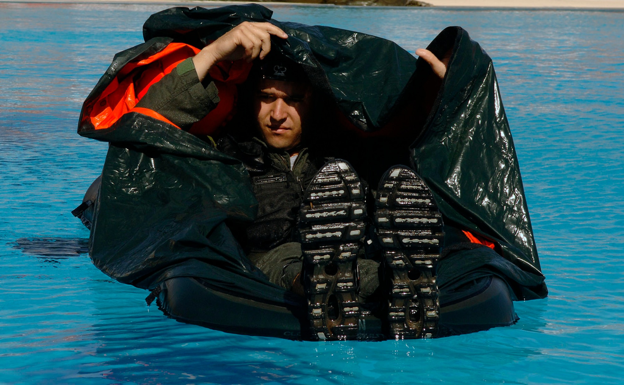 DYESS AIR FORCE BASE, Texas -- Airman 1st Class Andrew Blackmon, 7 OSS Life Support, demonstrates for a water survival training class the proper technique and operation of a single life raft, June 12. The single life raft was one of many demonstrations performed by Airman Blackmon, which included water landing, large raft operations, concealment, parachute escape, and rescue to name a few.  Water survival is part of continuous training and is required by all flight aircrew members.  (U.S. Air Force photo by Staff Sergeant Connor Estes).    