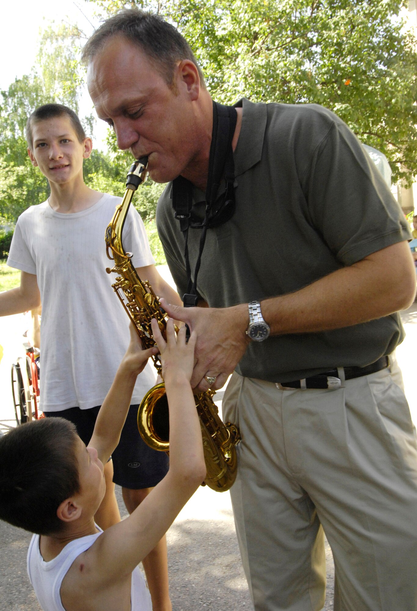 Saxophonist Master Sgt. Daniel Weber introduces the children of the Belovodosky Orphanage to his instrument June 14 in Kyrgyzstan. After the band performed at the orphanage, the children returned the favor by singing some of their favorite Russian military songs for the band members. (U.S. Air Force photo/Staff Sgt. Tabitha Kuykendall) 