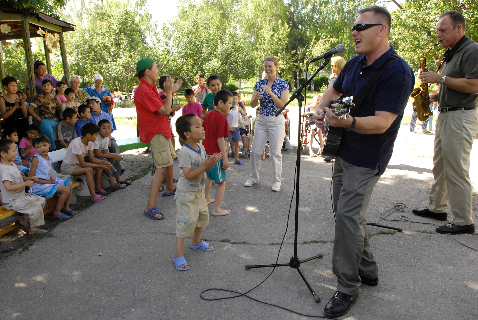 The U.S. Air Forces Central Band Falcon performs for the children of the Belovodosky Orphanage June 14 in Kyrgyzstan. After the band performed, the children returned the favor by singing some of their favorite Russian military songs for the band. (U.S. Air Force photo/Staff Sgt. Tabitha Kuykendall)