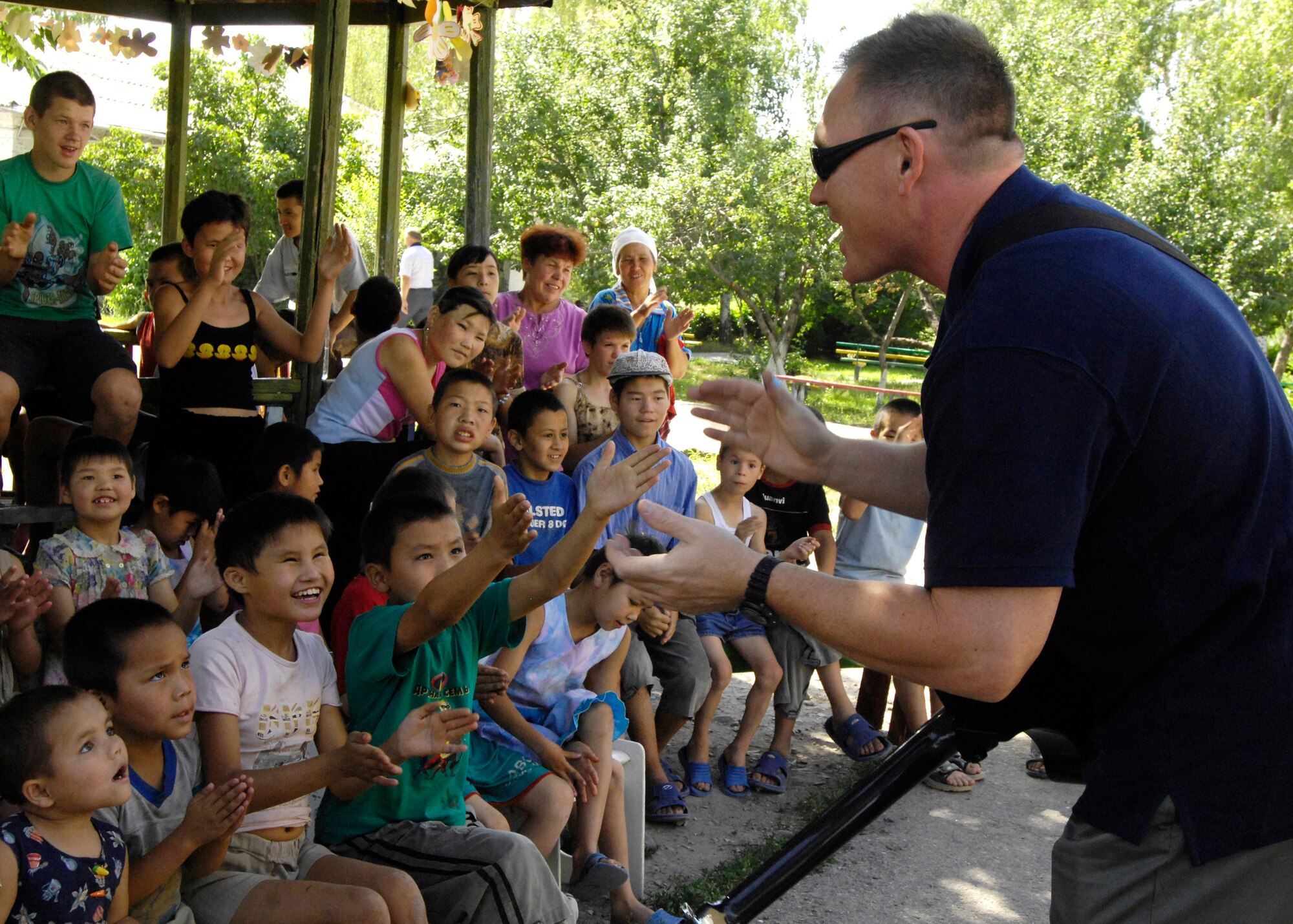 Senior Master Sgt. James Weber meets with children of the Belovodosky Orphanage June 14 in Kyrgyzstan. Sergeant Weber is a guitar player and vocalist for the U.S. Air Forces Central Band Falcon who performed at the orphanage. (U.S. Air Force photo/Staff Sgt. Tabitha Kuykendall) 