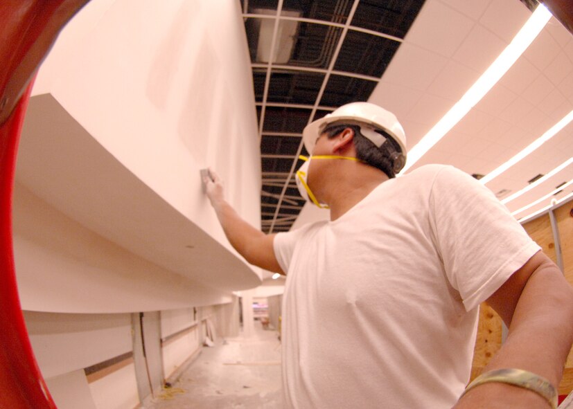 DYESS AIR FORCE BASE, Texas -- Pablo Dominquez sands down a wall in the meat department of the commissary, June 11. The renovation stared in December 2007 and will be completed by summer 2009. (U.S. Air Force Photo by Airman 1st Class Stephen Reyes)