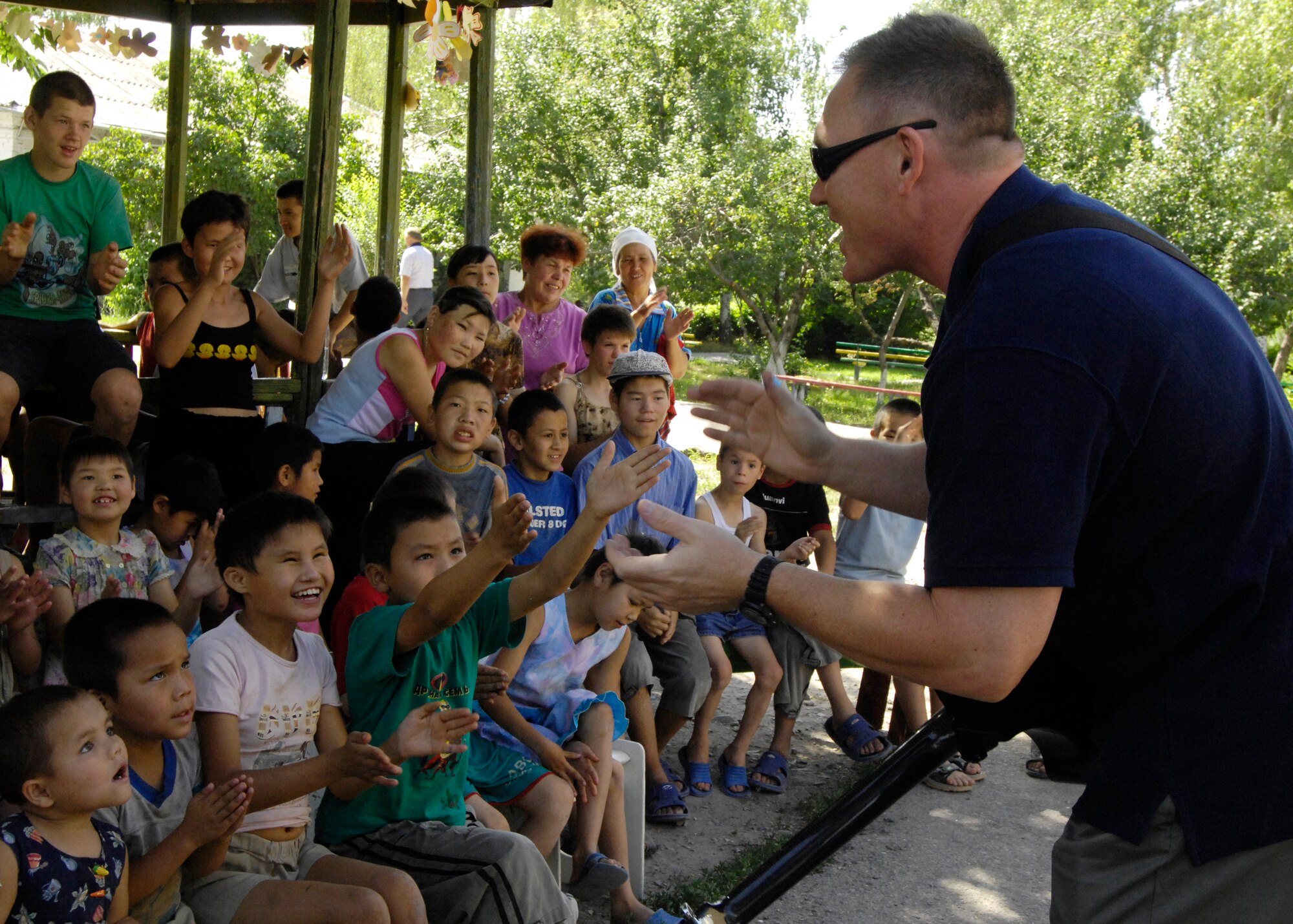 (08/06/14) SMSgt James Weber, guitar player and vocalist, U.S. Air Forces Central Band Falcon, meets the children of the Belovodosky Orphanage, Kyrgyz Republic during their performance today.  After AFCENT band performed at the orphanage, the children returned the favor by singing some of their favorite Russian military songs for the band.  (U.S. Air Force by Staff Sgt. Tabitha Kuykendall/ Released)