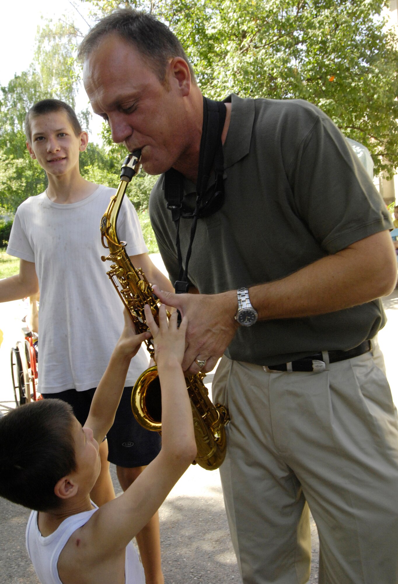 (08/06/14) Master Sgt. Daniel Weber, Saxophonist, U.S. Air Forces Central Band Falcon, introduces  the children of the Belovodosky Orphanage, Kyrgyz Republic, to his instrument.  After AFCENT band performed at the orphanage, the children returned the favor by singing some of their favorite Russian military songs for the band.  (U.S. Air Force by Staff Sgt. Tabitha Kuykendall/ Released)