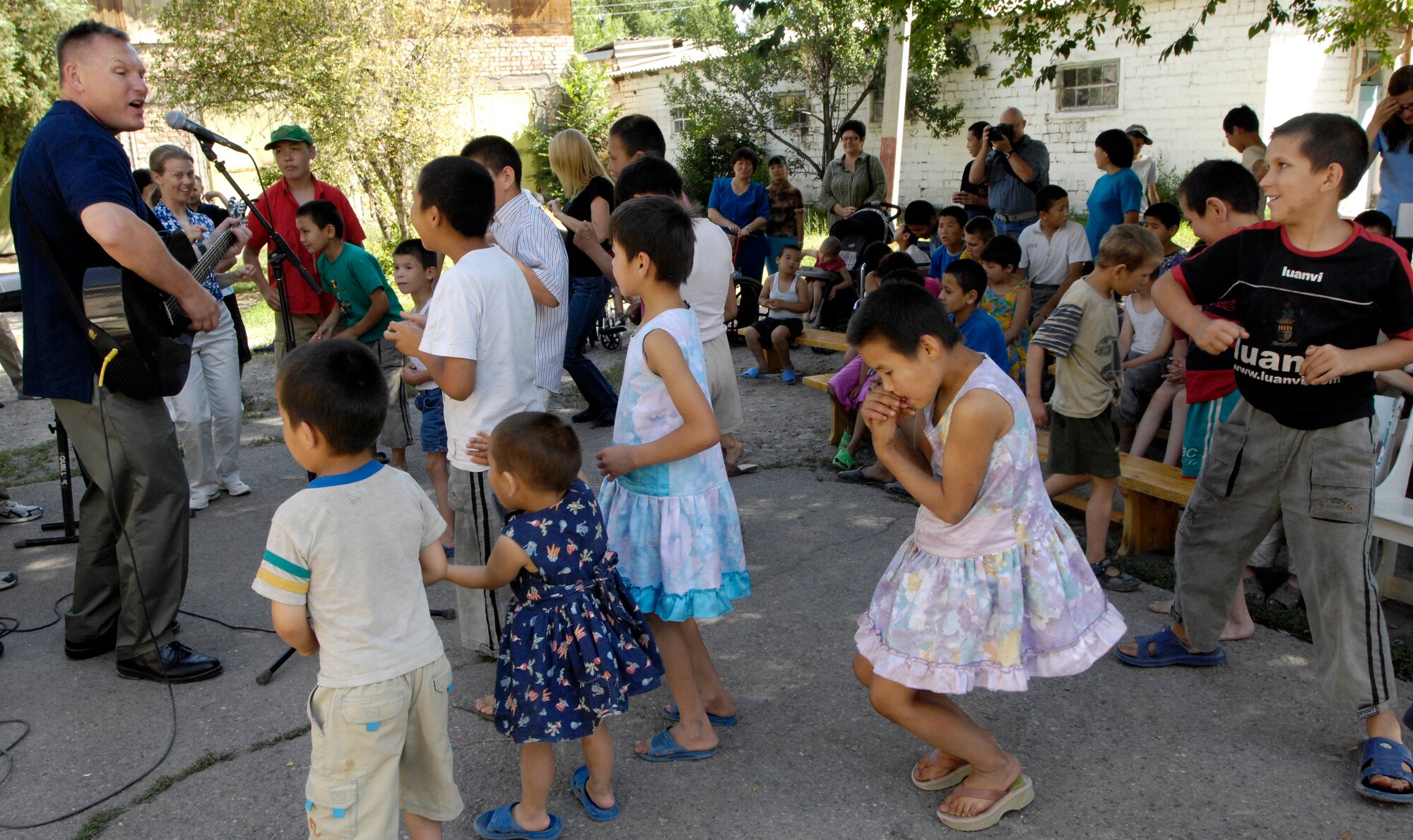 (08/06/14) Senior Master Sgt .James Weber, guitarist and vocalist, U.S. Air Forces Central Band Falcon, performs for the children of the Belovodosky Orphanage, Kyrgyz Republic today.  After AFCENT band performed at the orphanage, the children returned the favor by singing some of their favorite Russian military songs for the band.  (U.S. Air Force by Staff Sgt. Tabitha Kuykendall/ Released)