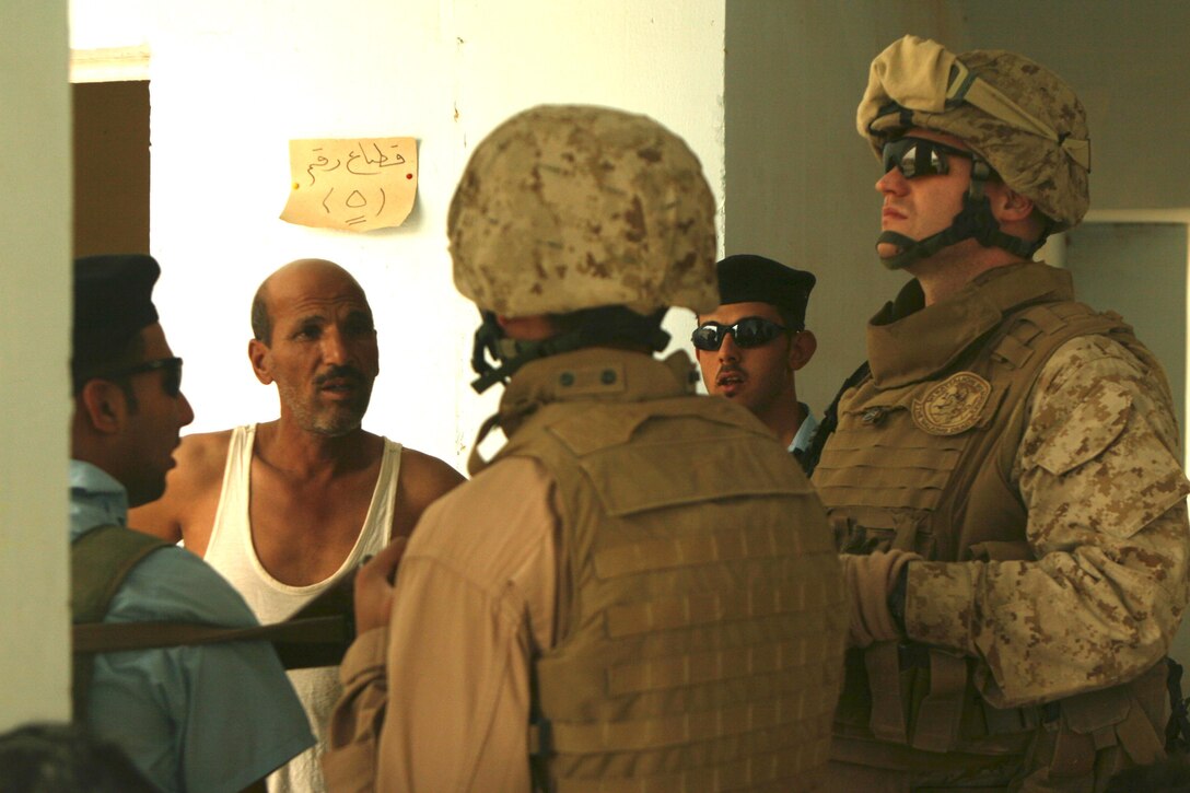 Staff Sgt. Earl Lucas, a platoon sergeant with Regimental Combat Team 1, listens to an Iraqi citizen detail the seriousness of structural damage at a boys and girls school in Ramadi June 18. Repairing the schools in Ramadi has been a key effort in the rebuilding stage. A number of schools in the city are in need of renovations due to structural damage and leaky roofs. “Repairing the schools is essential because it’s a school—it’s their future,” said Cpl. Chris Sarlo, a squad automatic weapon gunner with Weapons Company. “The children coming up now grew up around violence and fighting. Now that the fighting is over with, we need to focus on their education and hopefully make everything better in the region.”