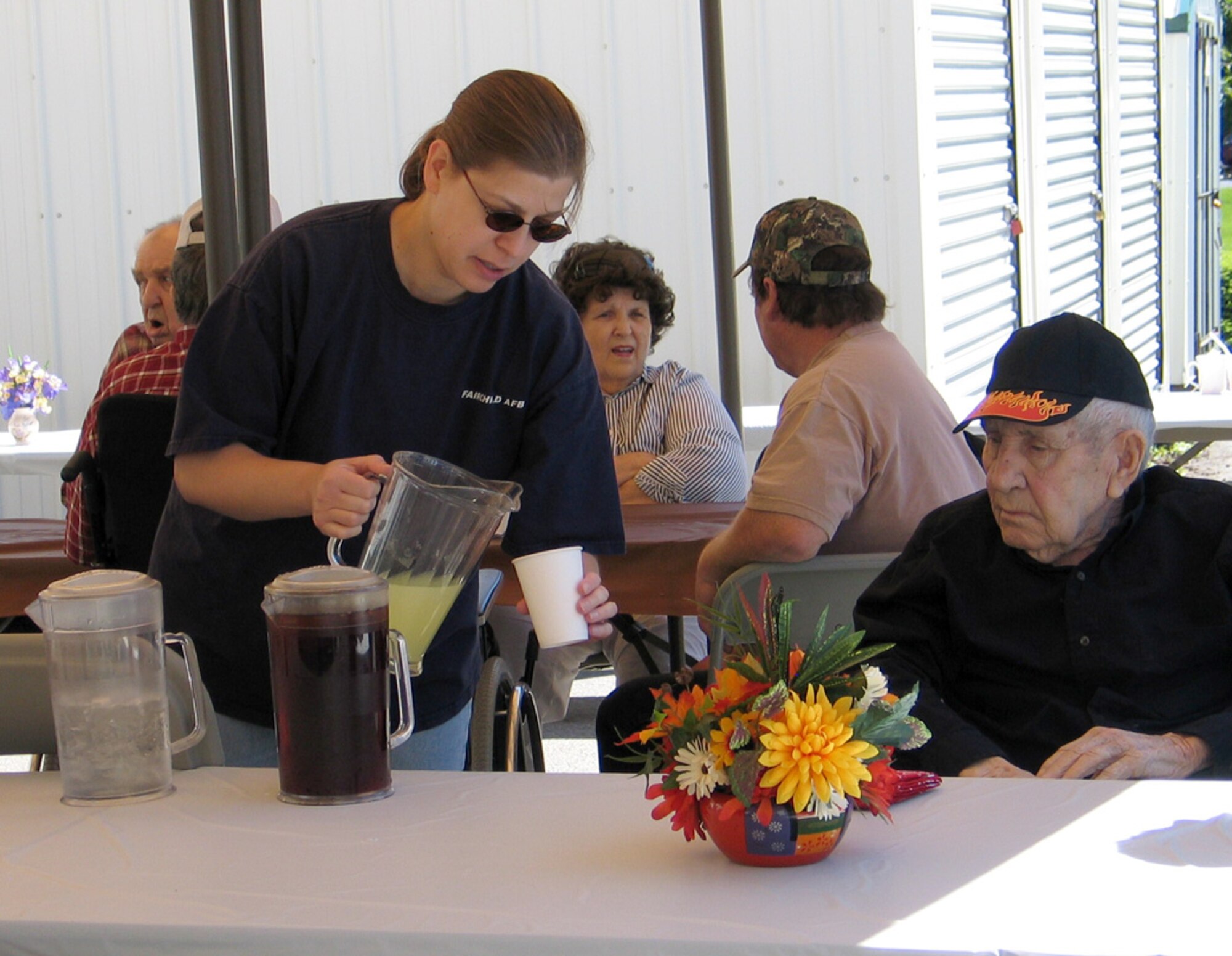 FAIRCHILD AIR FORCE BASE, Wash. – Tech. Sgt. Janet Boufard, 92nd Medical Group, serves lemonade to a resident of the Spokane Veterans Home June 14 at the home’s annual Father’s Day barbeque. Twenty two Fairchild volunteers, led by the Fairchild 5/6 Club, helped out at the event, and more than 250 people attended. (U.S. Air Force photo / Staff Sgt. Connie L. Bias)