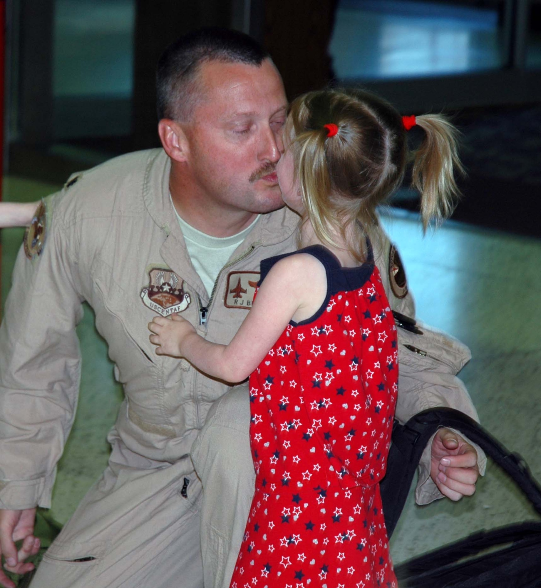 Lt. Col. Robert Buchanan, 944th Operations Support Flight commander, kisses his daughter, Kori, June 19 after returning home from a deployment to Joint Base Balad, Iraq. Colonel Buchanan deployed with the 124th Fighter Squadron of the Des Moines Iowa Air National Guard flying F-16s over Iraq. (U.S. Air Force photo/Tech. Sgt. Susan Stout) 