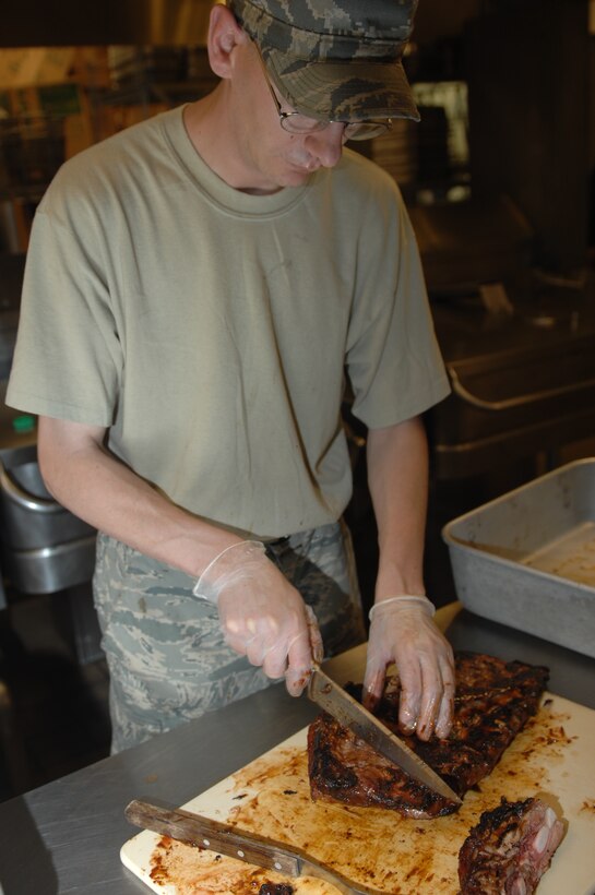 Staff Sgt. James Hill, 28th Force Support Squadron Food Services shift leader, cuts slices of barbecue ribs at the Ellsworth Air Force Base, S.D., Bandit Inn Dining Facility before the Airmen Appreciation Barbecue June 18, 2008. The meal included T-bone steak, barbecue ribs, barbecue chicken, macaroni and cheese, baked beans, corn on the cob and a dessert line. (U.S. Air Force photo/Airman 1st Class Joshua Seybert)
