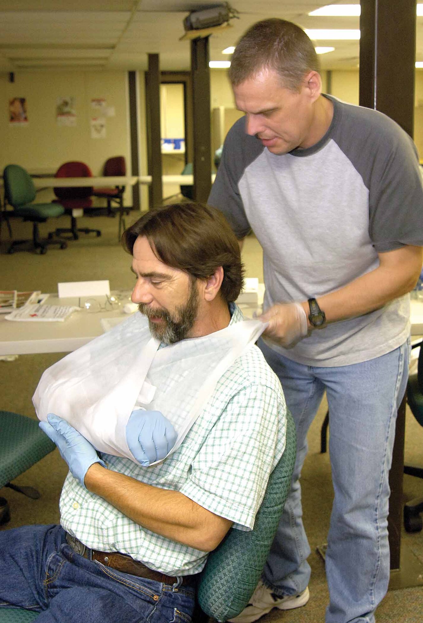 A rolled up newspaper and gauze form a splint for Don Califf’s arm as he and Aaron Adkins practice first aid techniques in a special First Responder’s class for 76th Maintenance Wing maintainers. (Air Force photos by Margo Wright)
