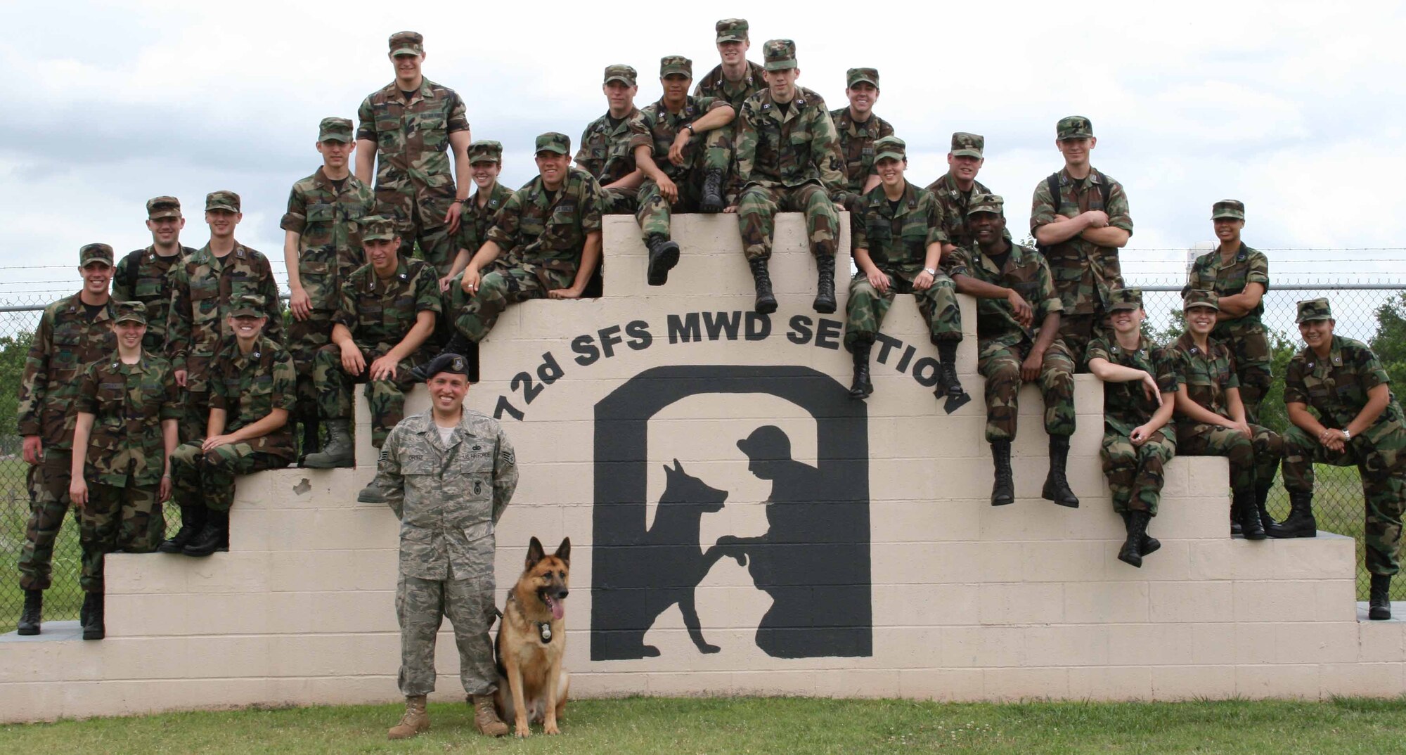 Cadets with Operation Air Force visited Tinker's Military Working Dog facility June 13 where they saw a demonstration by Staff Sgt. David Ortiz and Jambo.  The cadets are, front row from left,Christina Shirley, Jessica Nickle, Eric Paliuca, Jeffrey Reddout, Matthew Schenaker, Daniel Sargeant, Masha Scheglov, Ty Axson, Victoria McPartland, Amanda Reyes and Mireya Ortiz.  In the back row are Brnadon Geyer, Michael Eibling, Kenneth Baull, Tate Grogan, Dallas Wright, Celeste Noll, Braden Gross, Andrew Martin, Sue Guinane, Brent Kerns, Matthew Sobey and Brielle Hawkins.  Sergeant Ortiz and Staff Sgt. Richard Duvall took time with the cadets when they first arrived to the K-9 facilities and discussed various tsopics concerning the working dogs.  Operation Air Force brought 27 cadets out of the classroom and into the active Air Force to prepare them for leadership roles.  (Air Force photo by Danielle Gregory)