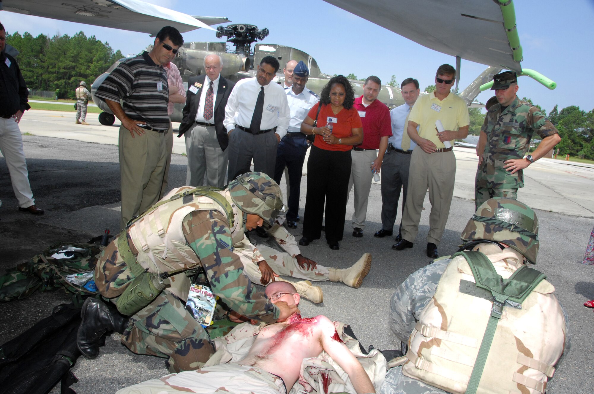 Senior Airman Jason Bailey and Staff Sgt John Cleaves, 78th Medical Group, tend to A1C Jeffrey Minkel, 78th Security Forces, during a moulage demonstration for honorary commanders June 16. U. S. Air Force photo by Claude Lazzara