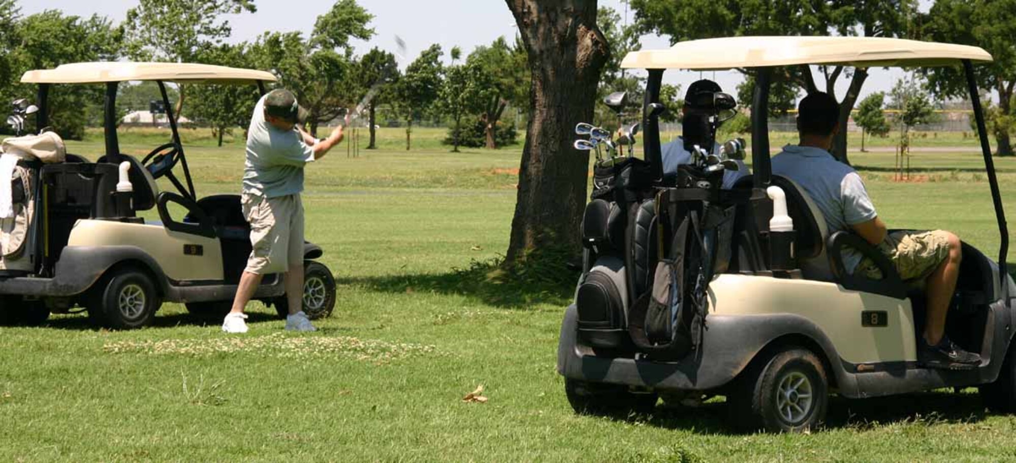 Master Sgt. Daniel Martin, 72nd Security Forces Squadron, prepares to shoout of of the rough and hopefully make the green, while friends look on.  (Air Force photo by Kimberly Woodruff)