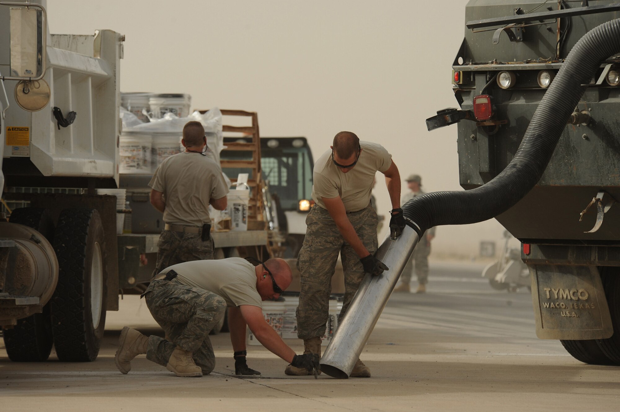 SATHER AIR BASE, Iraq -- Tech. Sgt. Wayne Lawton (kneeling) and Tech. Sgt. Paul Evans of the 447th Expeditionary Civil Engineer Squadron remove debris from an area of the Baghdad International Airport runway during a spall repair project here June 7. Spall repair is required to patch deteriorating areas of the runway. Sergeants Lawton and Evans are deployed to Iraq from the 174th Civil Engineer Squadron, Syracuse, N.Y. (U.S. Air Force photo/Tech. Sgt. Jeffrey Allen)