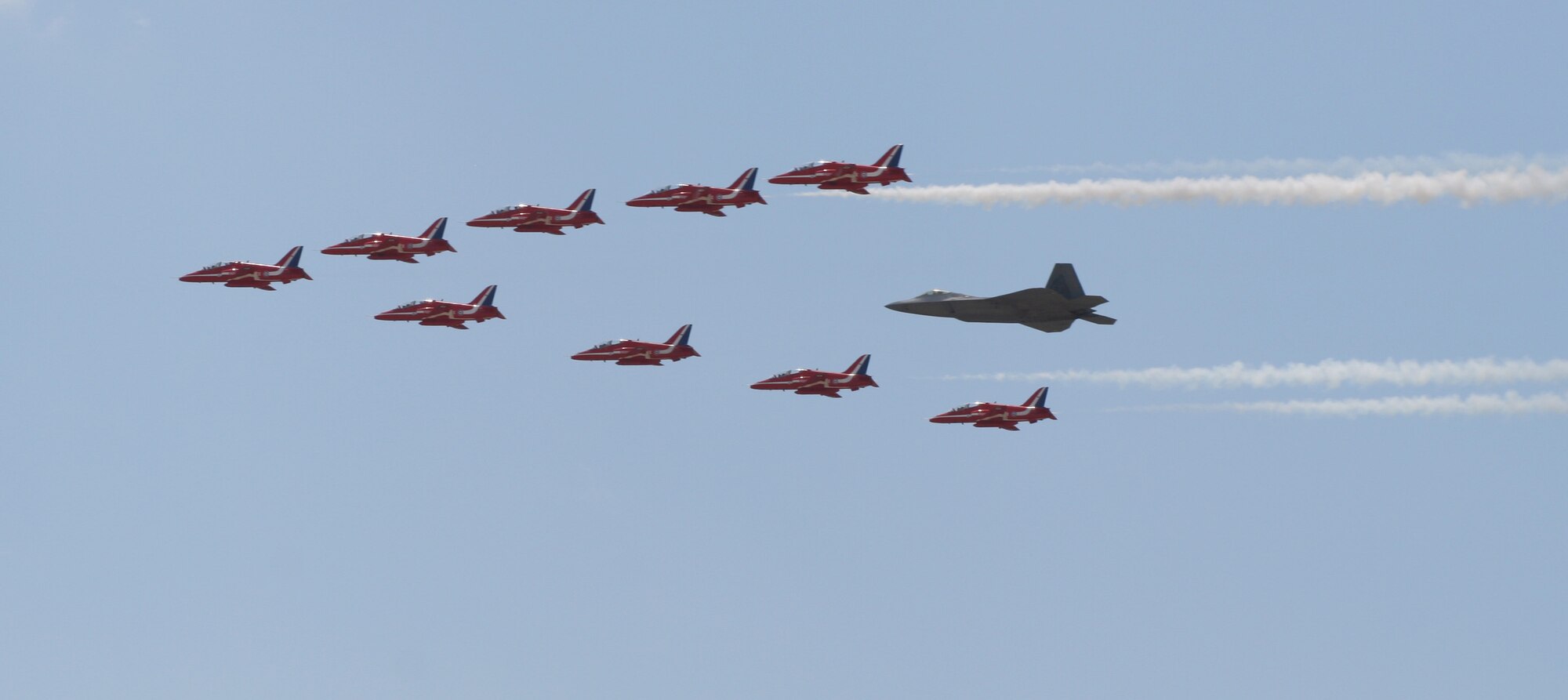 LANGLEY AIR FORCE BASE, Va. - Maj. Paul "Max" Moga, F-22A Raptor
Demonstration Team pilot, flies in formation with British Royal Air Force
Aerobatic Team, The Red Arrows, during an afternoon practice flight here
June 18. Both demonstration teams will perform at AirPower over Hampton
Roads, Langley's air show, which is scheduled for June 20 to 22.