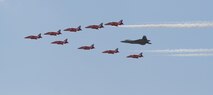 LANGLEY AIR FORCE BASE, Va. - Maj. Paul "Max" Moga, F-22A RaptorDemonstration Team pilot, flies in formation with British Royal Air ForceAerobatic Team, The Red Arrows, during an afternoon practice flight hereJune 18. Both demonstration teams will perform at AirPower over HamptonRoads, Langley's air show, which is scheduled for June 20 to 22.