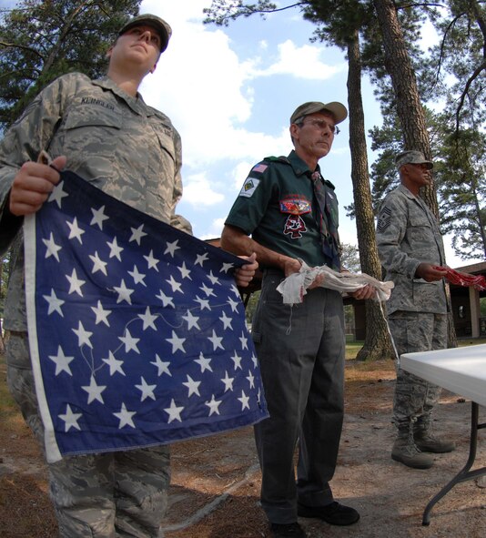 SEYMOUR JOHNSON AIR FORCE BASE, N.C. - Staff Sgt. Jessica Klingler, Troop 8 Leader Dewey Offield and Command Chief Master Sgt. Leroy Frink await to retire individual pieces of an American flag for the opening of a flag retirement ceremony here June 14. (U.S. Air Force photo by Airman 1st Class Gino Reyes) 