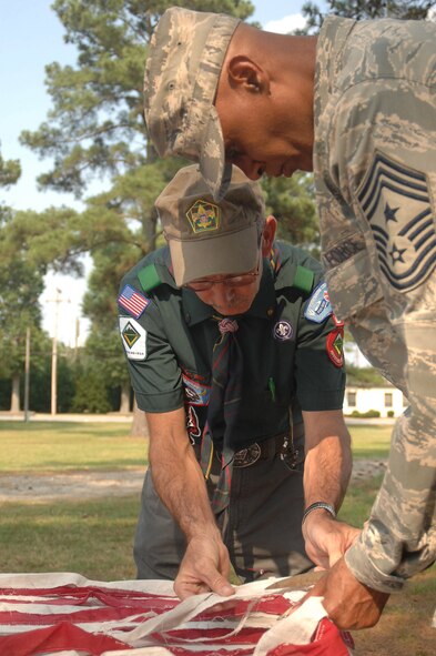 SEYMOUR JOHNSON AIR FORCE BASE, N.C. - Dewey Offield and Command Chief Master Sgt. Leroy Frink cut an American flag here June 14. Mr. Offield and Chief Frink were participating in a flag retirement ceremony to show respect and honor to worn, faded U.S. flags. (U.S. Air Force photo by Airman 1st Class Makenzie R. Lang) 