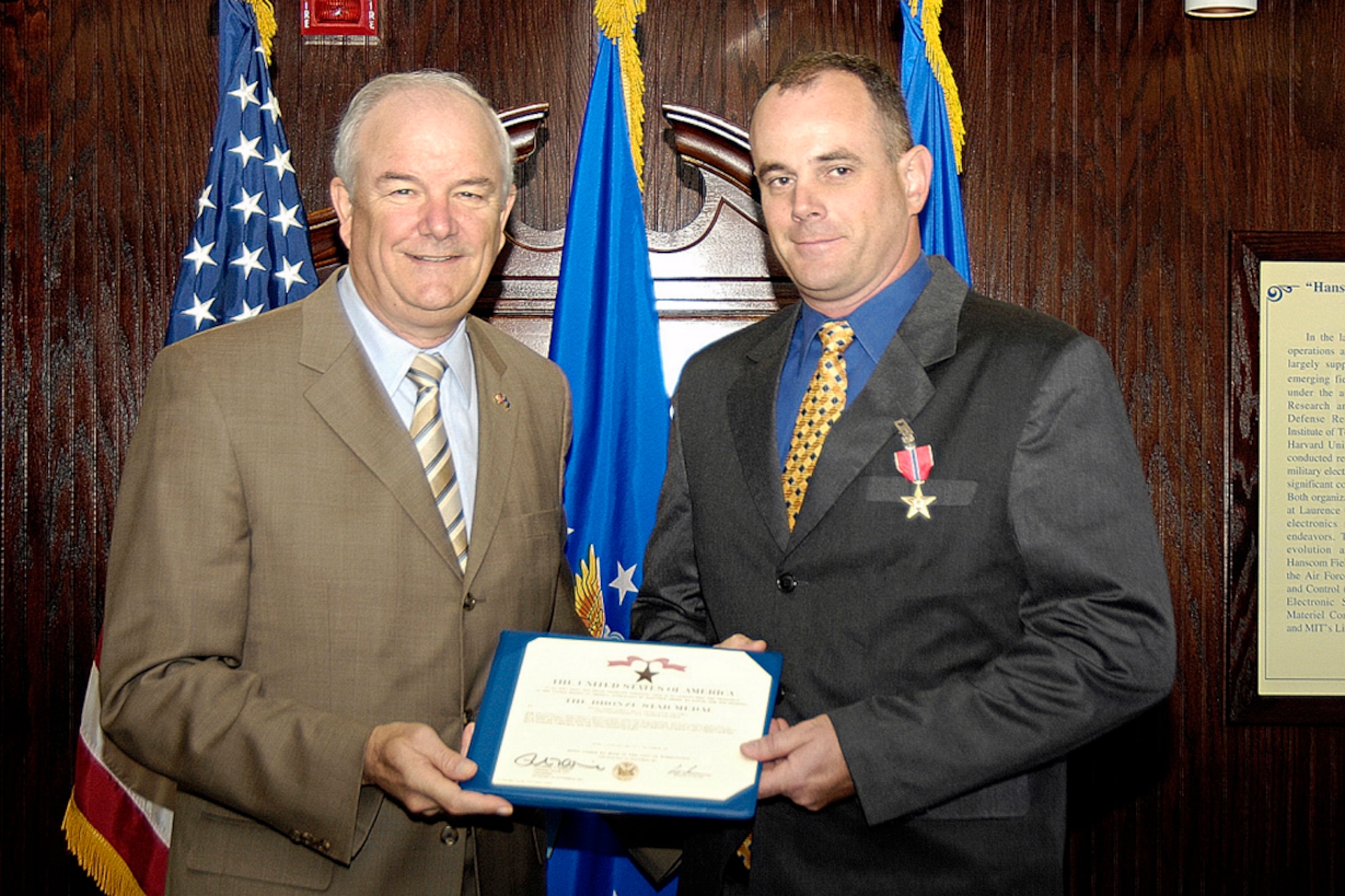 HANSCOM AFB, Mass. -- Secretary of the Air Force Michael W. Wynne (left), presents Special Agent James E. Mills (right), Air Force Office of Special Investigations, Det.102, with the Bronze Star here June 18 for distinguishing himself by exceptionally meritorious conduct in performance of outstanding service to the United States as a Weapons Intelligence Investigator. (U.S. Air Force photo by Linda LaBonte Britt.)