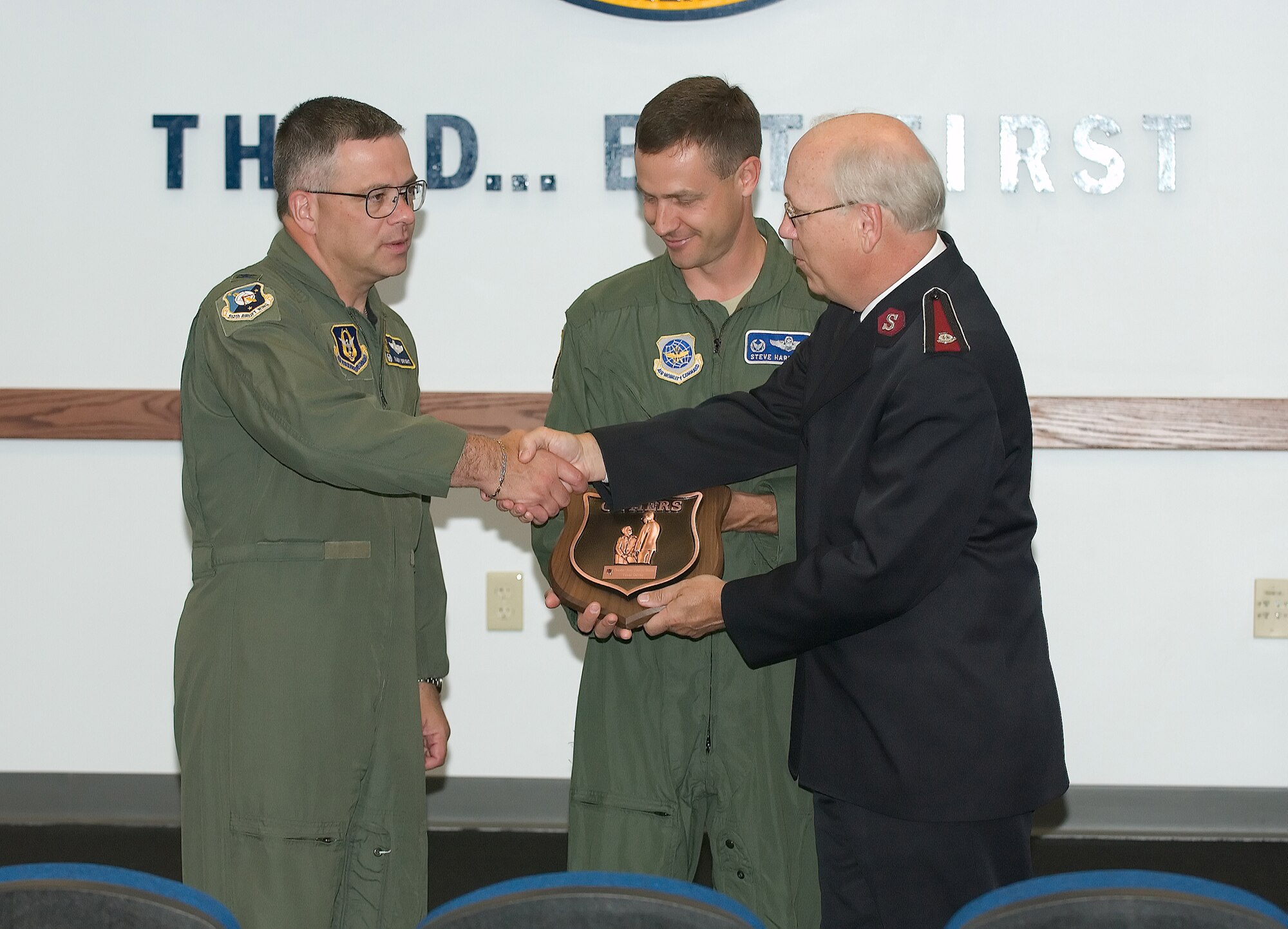 Col. William Carlson, right, divisional commander of the Salvation Army, presents the Others Award to Col. Randal Bright, 512th Airlift Wing commander, left, and Col. Steven Harrison, 436th Airlift Wing commander, June 4.  The award was presented on to all of Team Dover as recognition for the base’s continuing support of Salvation Army programs.   U.S. Air Force photo by Jason Minto.