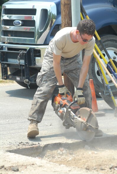 Senior Airman Ryan Thomas, 43rd Civil Engineer Squadron, cuts out a section of concrete at the Willow Lakes Golf Course June 10. The project involved removing old brick flower pots and relacing them with asphalt. (U.S. Air Force Photo by Airman 1st Class Mindy Bloem)