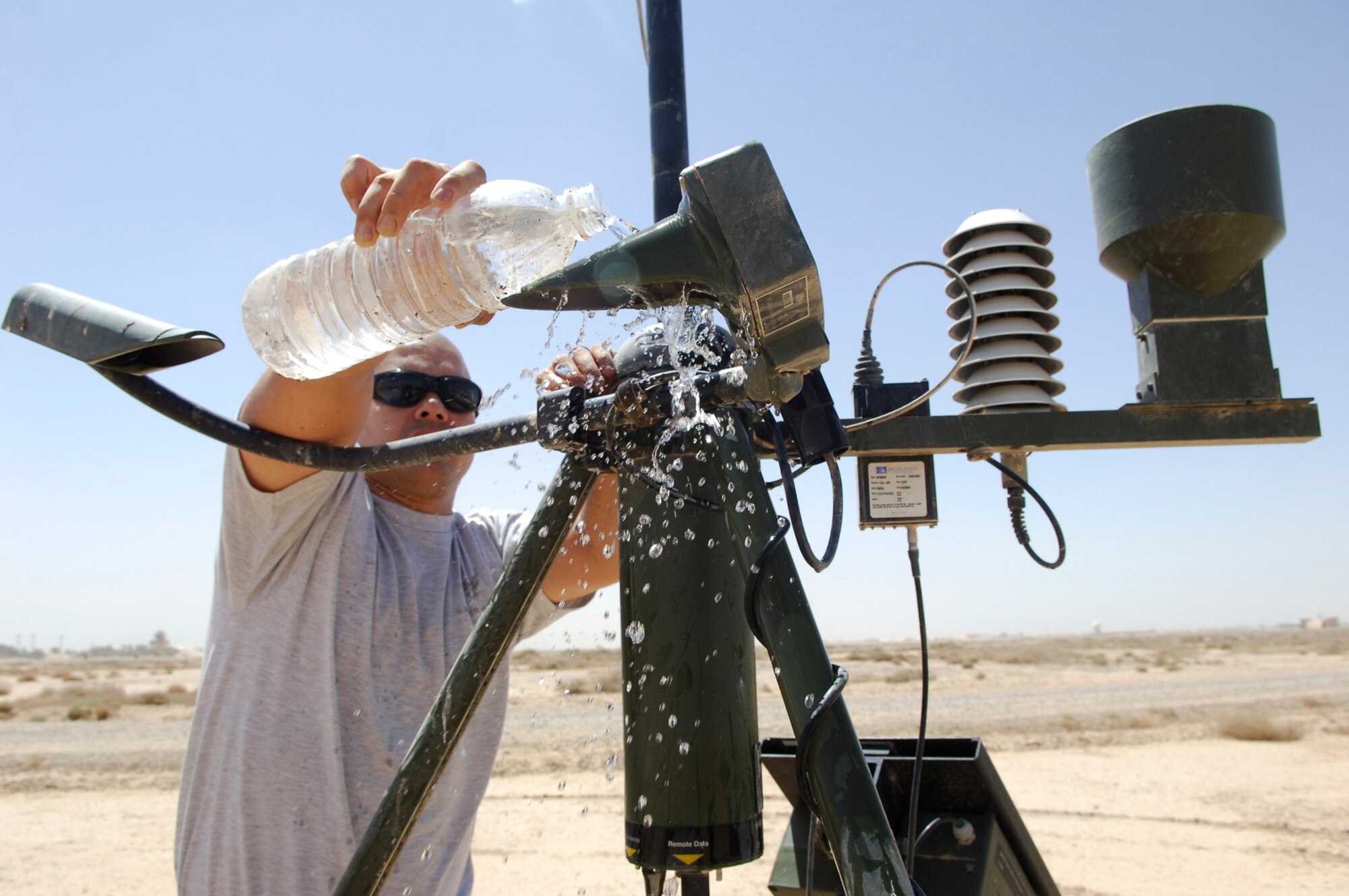 JOINT BASE BALAD, Iraq -- Staff Sgt. Donald Blasini, a 332nd Expeditonary Operations Support Squadron combat weather forecaster, cleans the sensors on a piece of tactical weather equipment here, June 14. The two sensors are about six inches apart and monitor the space between them to determine the visibility on the airfield. Airmen are authorized to wear either the airman battle uniform or physical fitness uniform when cleaning the weather equipment. Sergeant Blasini is deployed from Shaw Air Force Base, S.C. (U.S. Air Force photo /Staff Sgt. Mareshah Haynes)