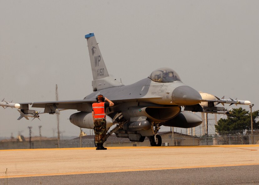 KUNSAN AIR BASE, Republic of Korea—Senior Airman Evan Johnson a crew chief from the 80th Aircraft Maintenance Unit salutes a pilot from the 35th Fighter Squadron here 19 June during the Max Thunder exercise. Training side-by-side is part of day-to-day operations for ROKAF and USAF forces at Kunsan Air Base. The bi-lateral training received during Max Thunder will not only improve interoperability, but is also intended to assist the ROKAF prepare for RED FLAG Nellis in August 2008.  (U.S. Air Force Photo/Staff Sgt Araceli Alarcon)
