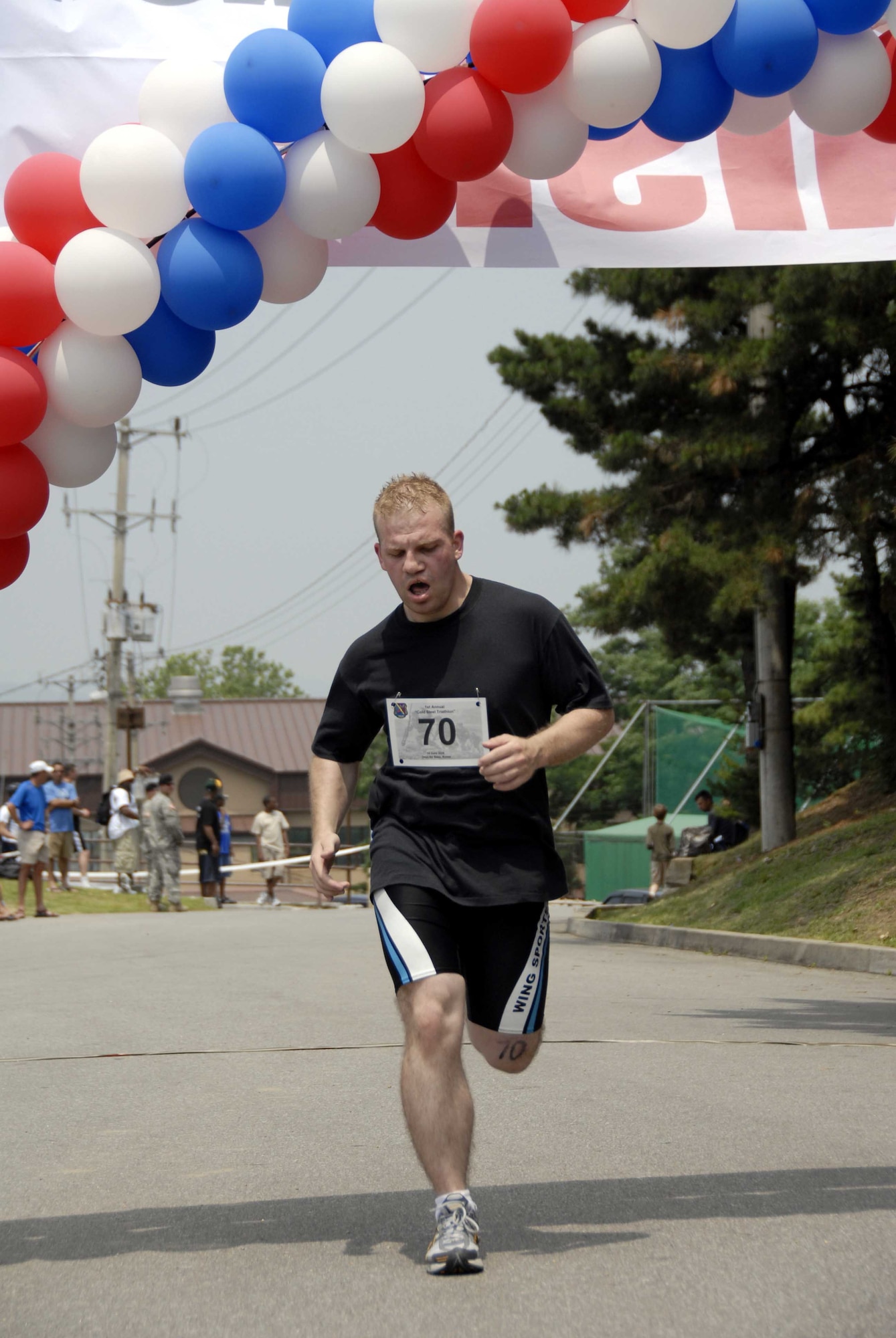 OSAN AIR BASE, Republic of Korea – Staff Sgt. John Adams, 303rd Intelligence Squadron, crosses the finish line during the Cold Steel Triathlon held June 14. The top three winners in their respective age categories were presented with medals at the event’s conclusion. (U.S. Air Force photo/Senior Airman Christopher Boitz)
