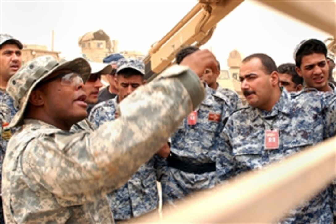 U.S. Army Sgt. Franklin Myers points out various functions located on a Buffalo route clearance vehicle to members of the Iraqi National Police on Forward Operating Base Falcon, Baghdad, Iraq, June 16, 2008. Myers is assigned to the 4th Infantry Division's Company E, 4th Battalion, 64th Armor Regiment, 4th Infantry Division.