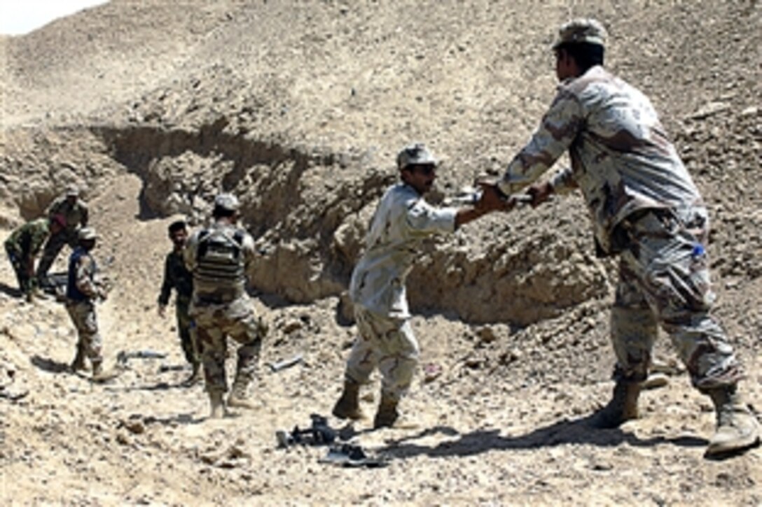 Members of an Iraqi army bomb disposal company establish a line to pass along unexploded ordnance for a controlled detonation during a training exercise, Tikrit, Iraq, June 10, 2008.  
