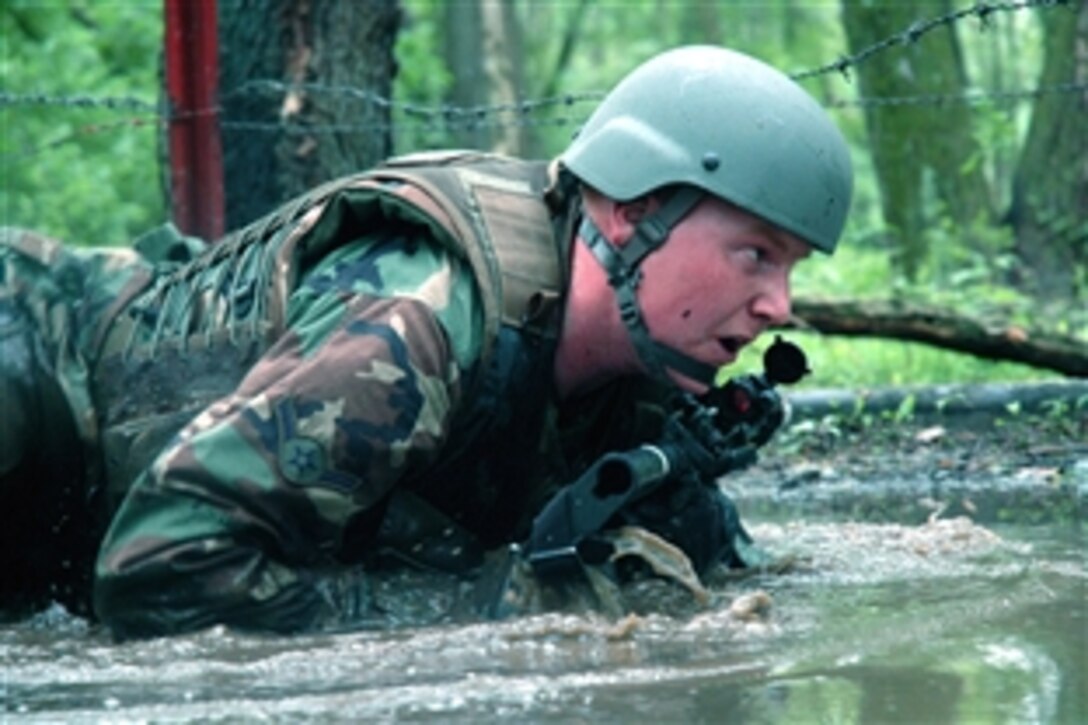 A student in the Air Force Phoenix Warrior Training Course crawls under barbed wire and through water during combat first aid training on Fort Dix, N.J., June 5, 2008.