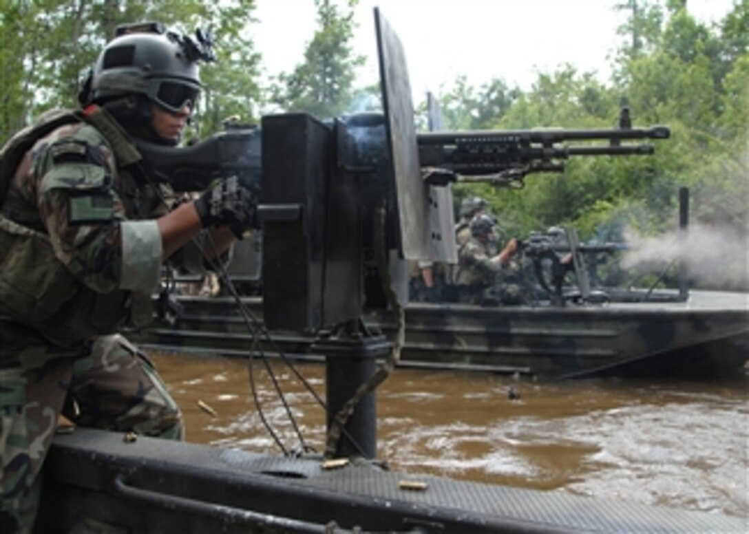 A Special Warfare Combatant-craft crewmember assigned to Special Boat Team 22 fires an M-240N 7.62-mm machine gun during an exercise at the new riverine live-fire training range at Stennis Space Center in Mississippi on June 17, 2008.  