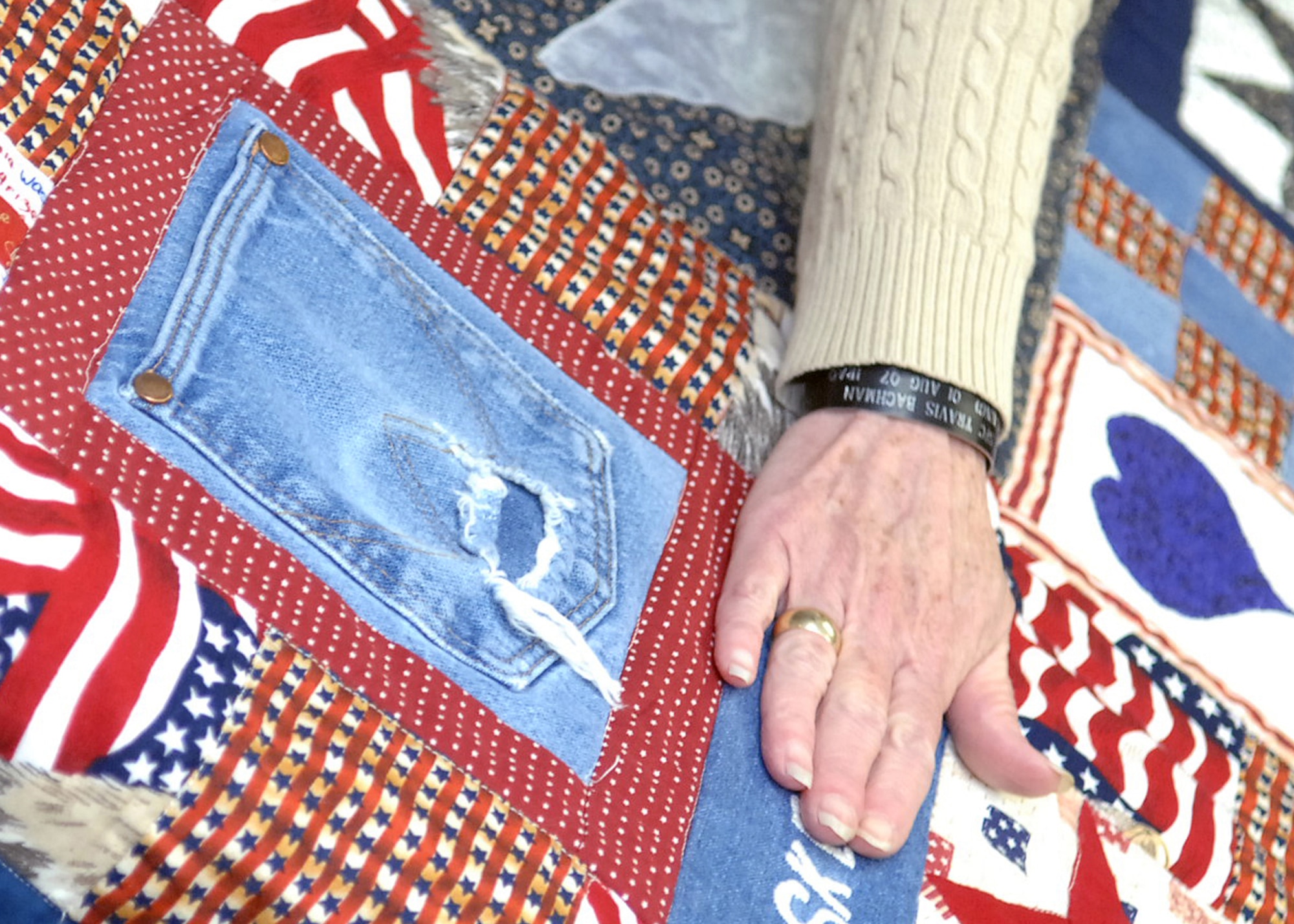 CANNON AIR FORCE BASE, N.M. -- Connie Bachman, mother Sgt. 1st Class Travis Bachman, rubs her hand across one of the quilts presented to her and her family by the Caprock Quilters on June 20. The memorial quilts were made to honor the NCO who was killed by an improvised explosive device on Aug, 1, 2007. (Air Force photo by Airman 1st Class Danielle Martin)