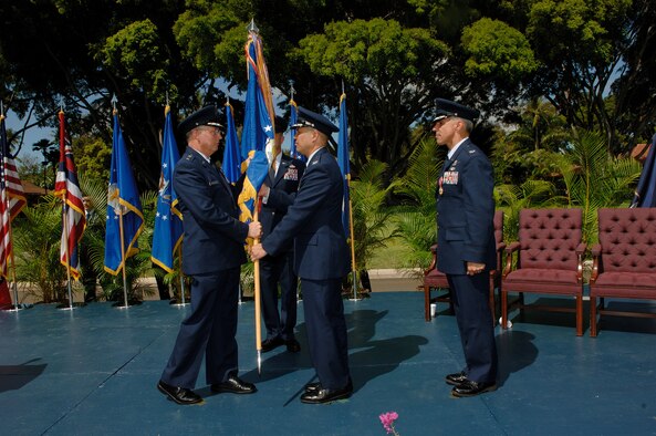 HICKAM AIR FORCE BASE, Hawaii -- Col. Giovanni K. Tuck takes the 15th Airlift Wing Flag from Lt. Gen. Lloyd S. "Chip" Utterback, 13th Air Force commander, during a change of command ceremony at the Freedom Tower Mall June 20.  (U.S. Air Force Photo/Mark Bates) 